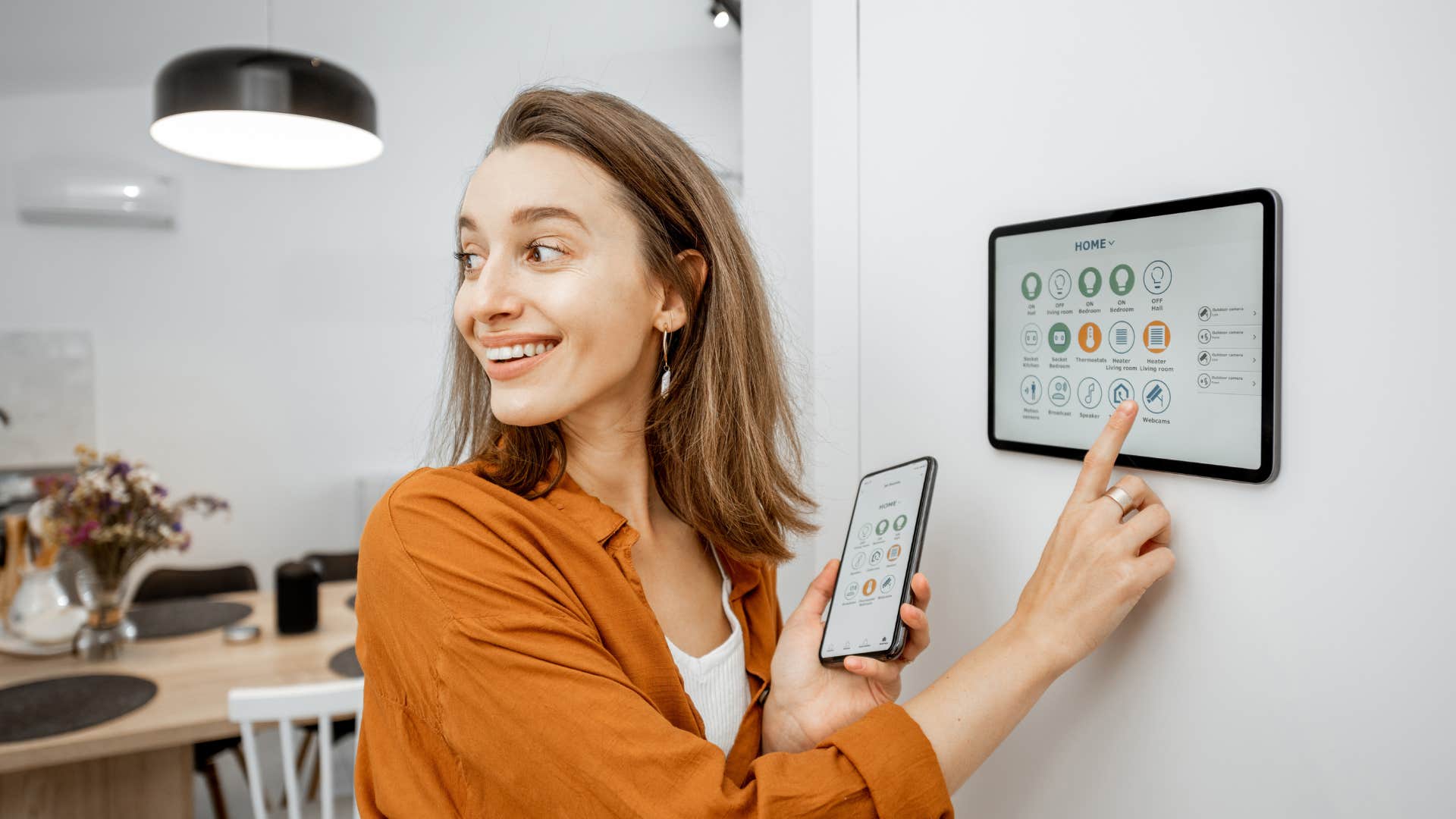 a woman uses an expensive gadget to control the lighting in her home