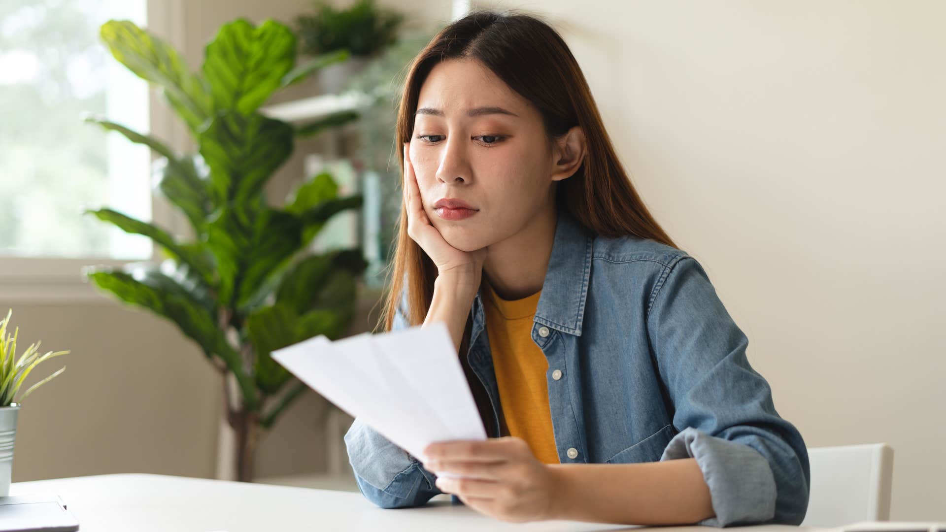 a woman looks over her high credit card bills