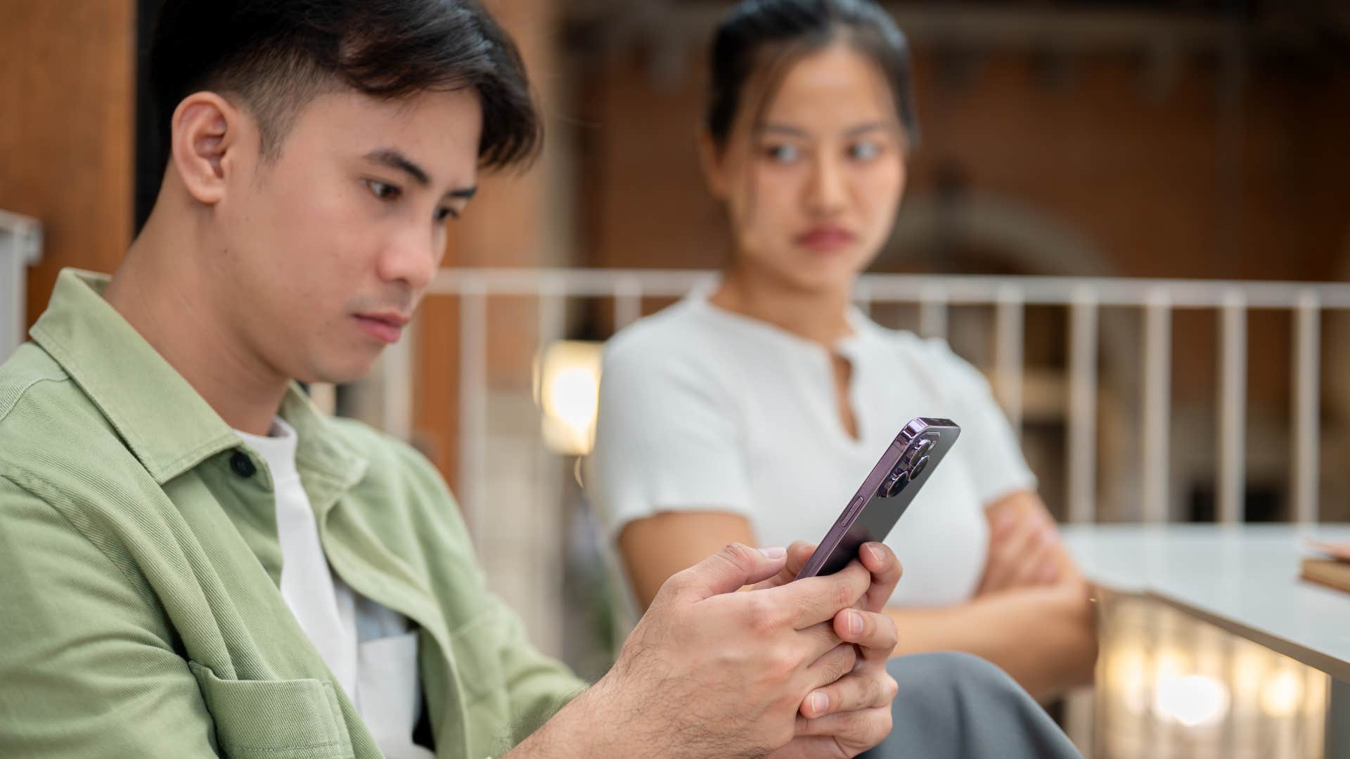 man who is a type-a control freak as he checks woman's gadgets