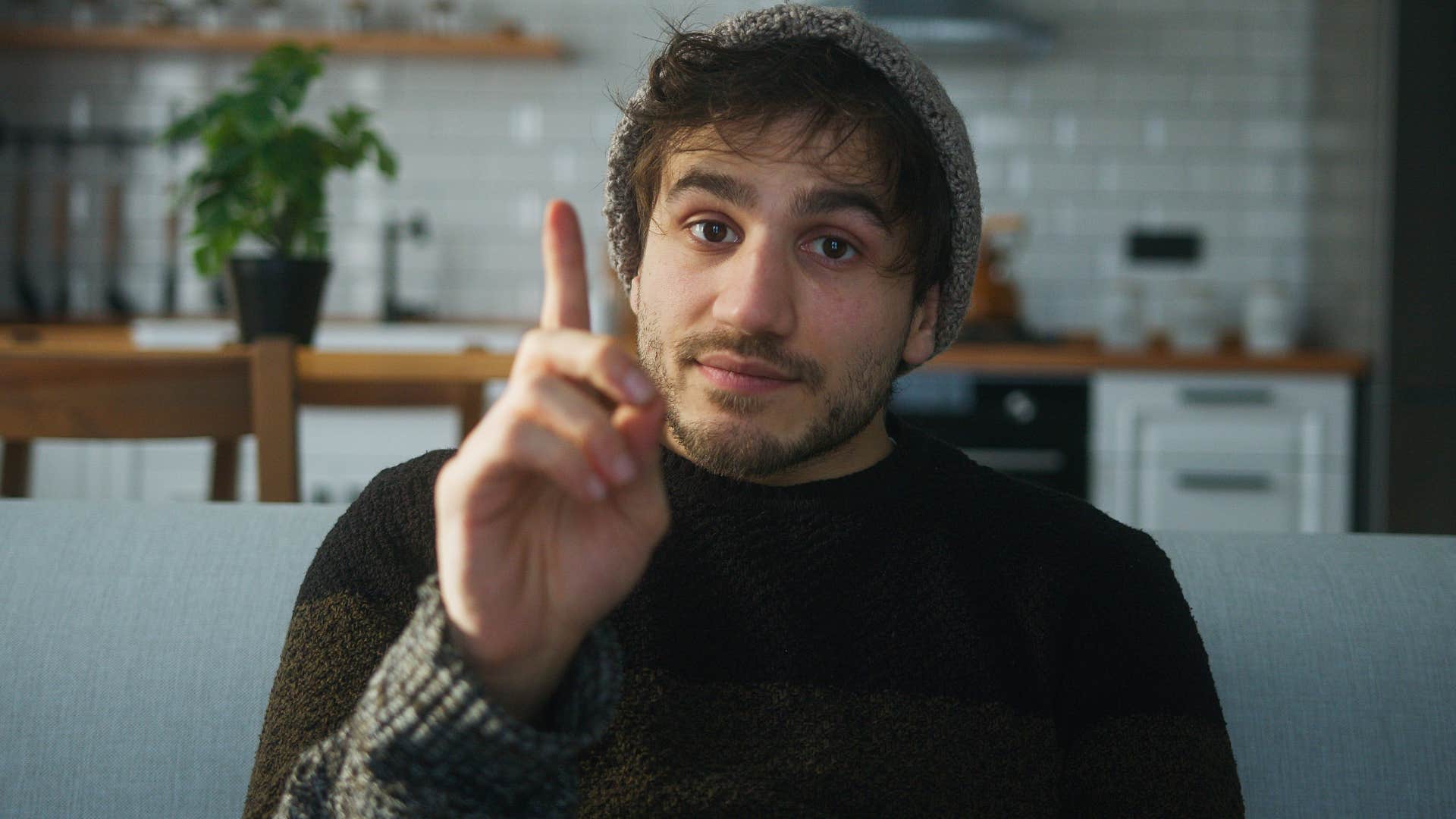man about to interrupt holding his finger up