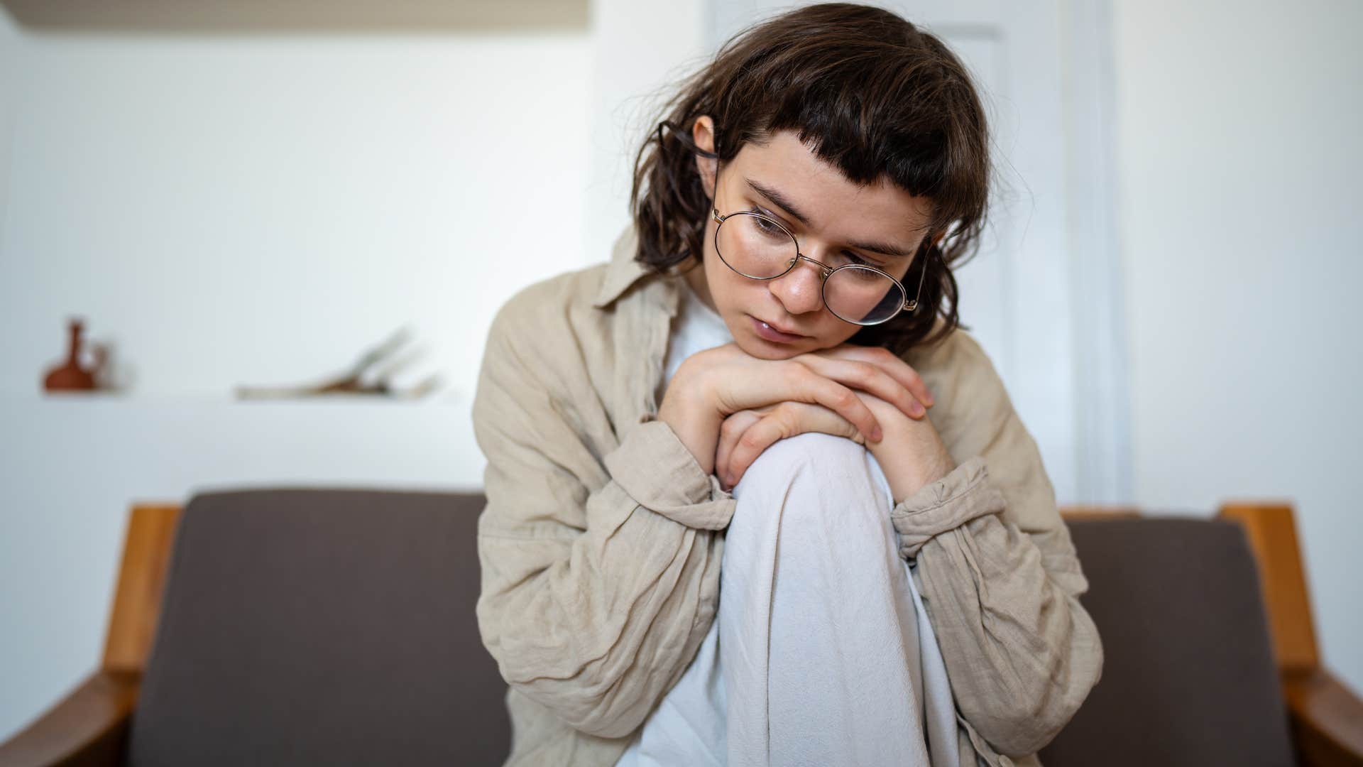 Woman with low energy vibes sitting at home.