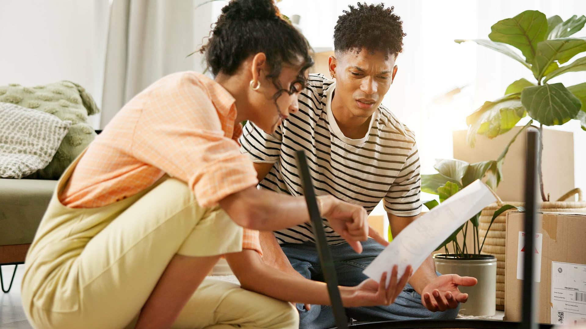 Couple looking at a million unfinished projects in their living room.