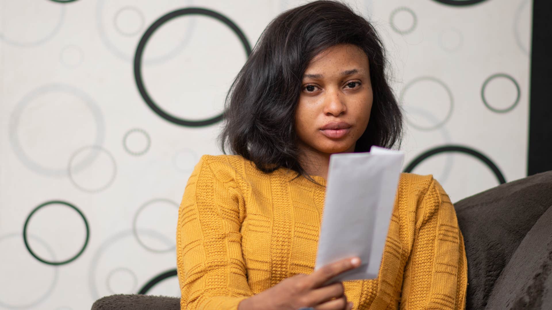 Woman looking at unopened mail at home.