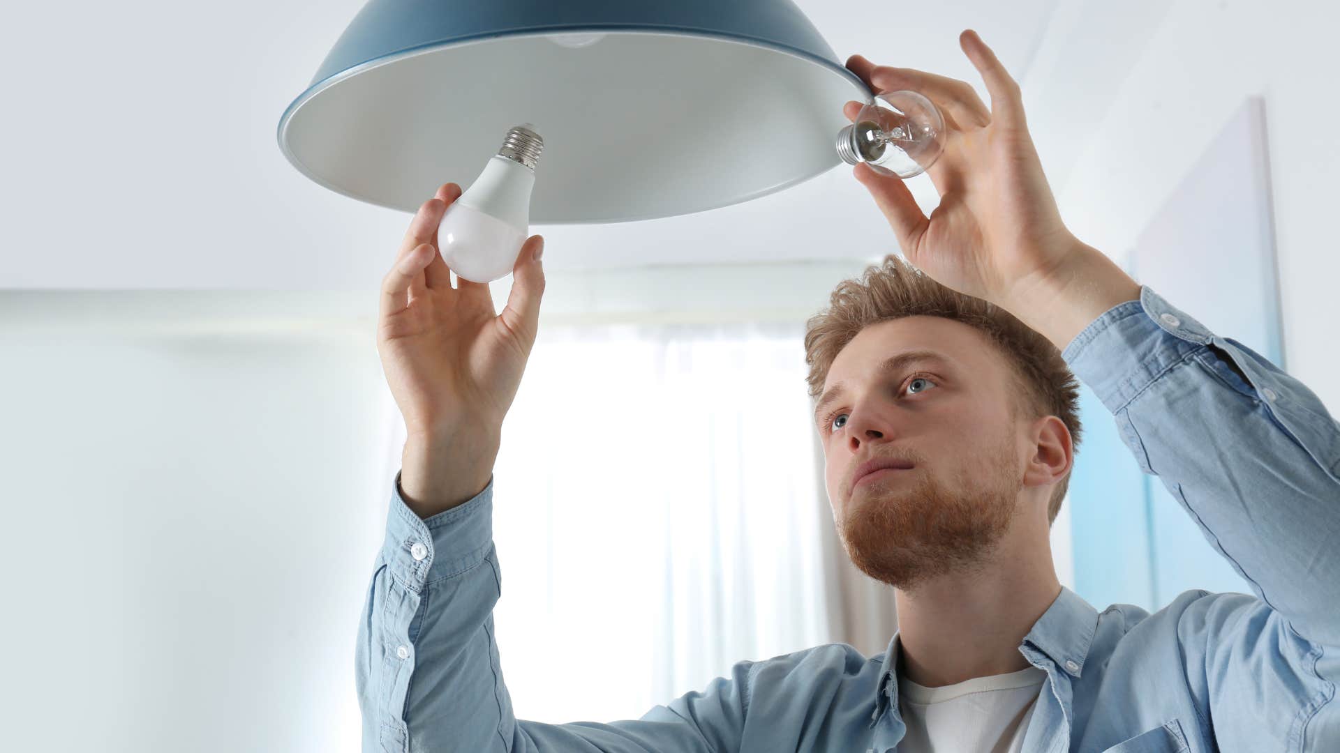 Man fixing broken furniture and burnt out lightbulbs at his parents' house.