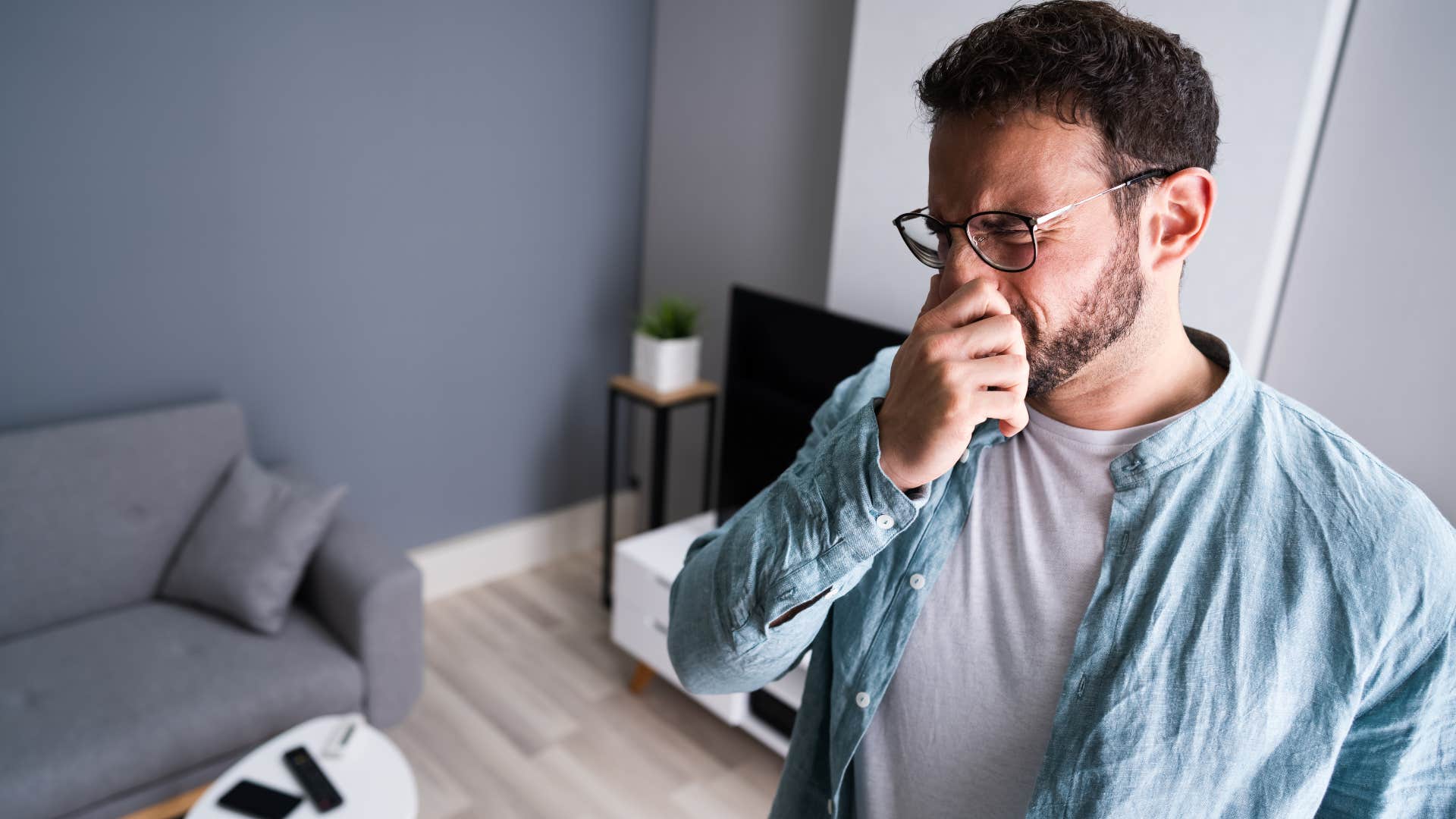 Man plugging his nose because of an unpleasant smell.