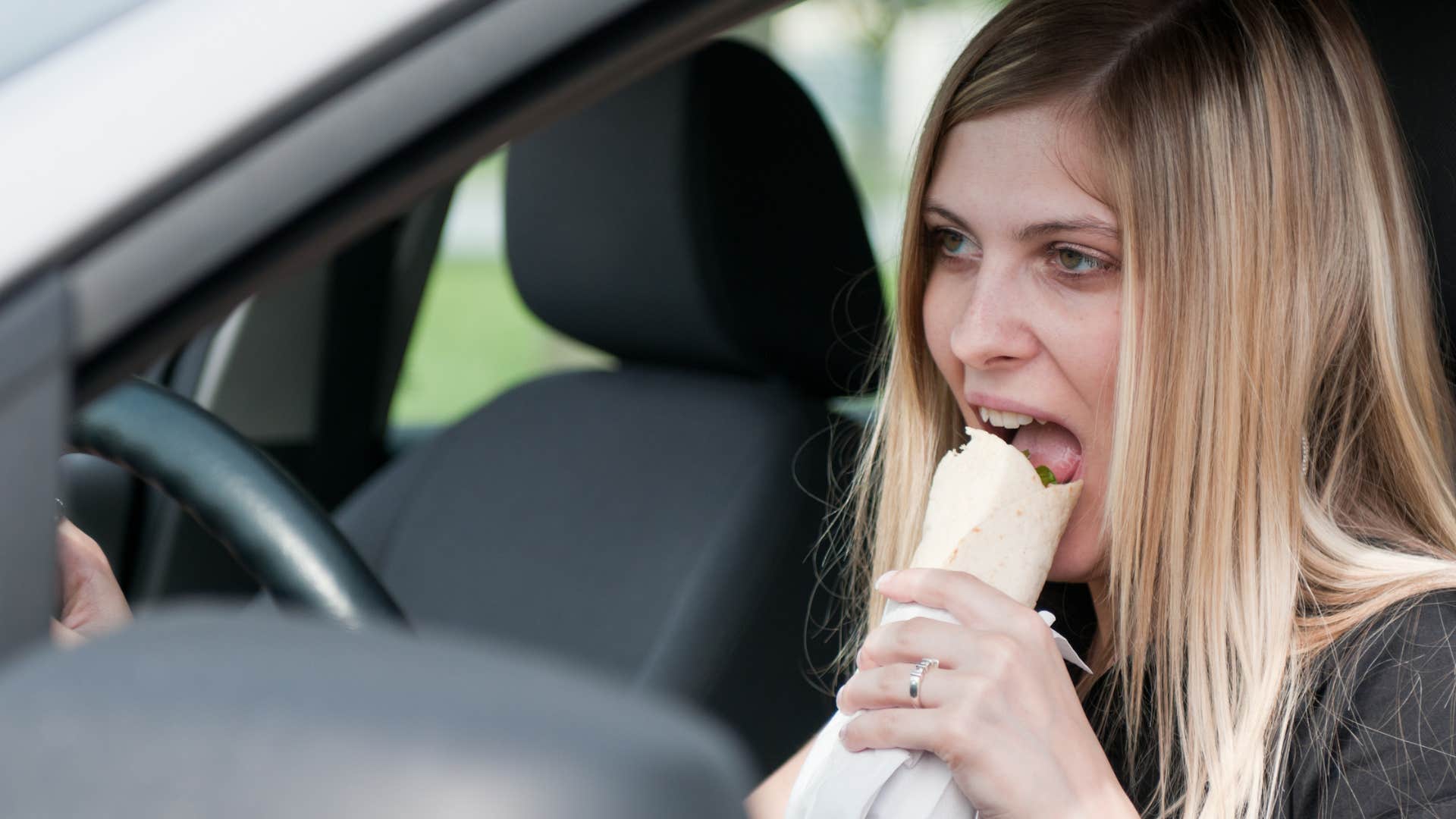 woman eating in her car creating crumbs and stains