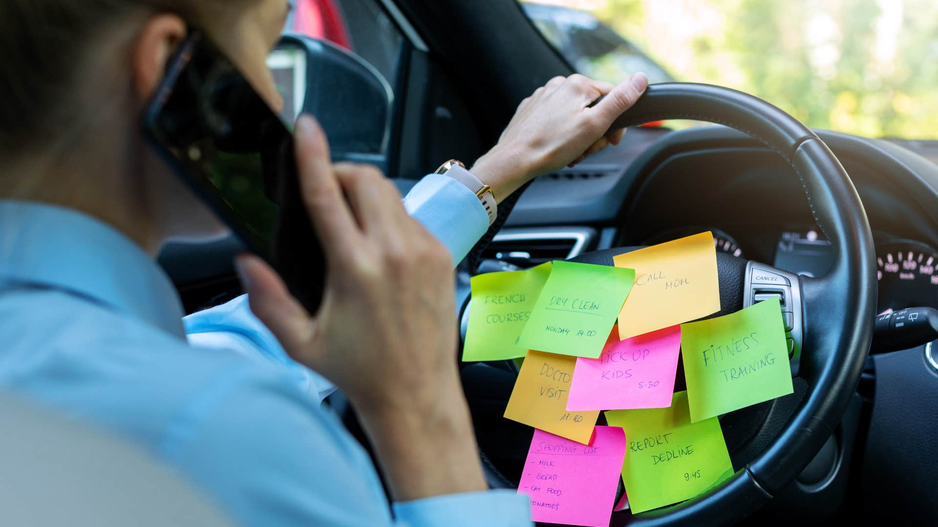 concerned man in his wifes car with sticky notes all over the steering wheel