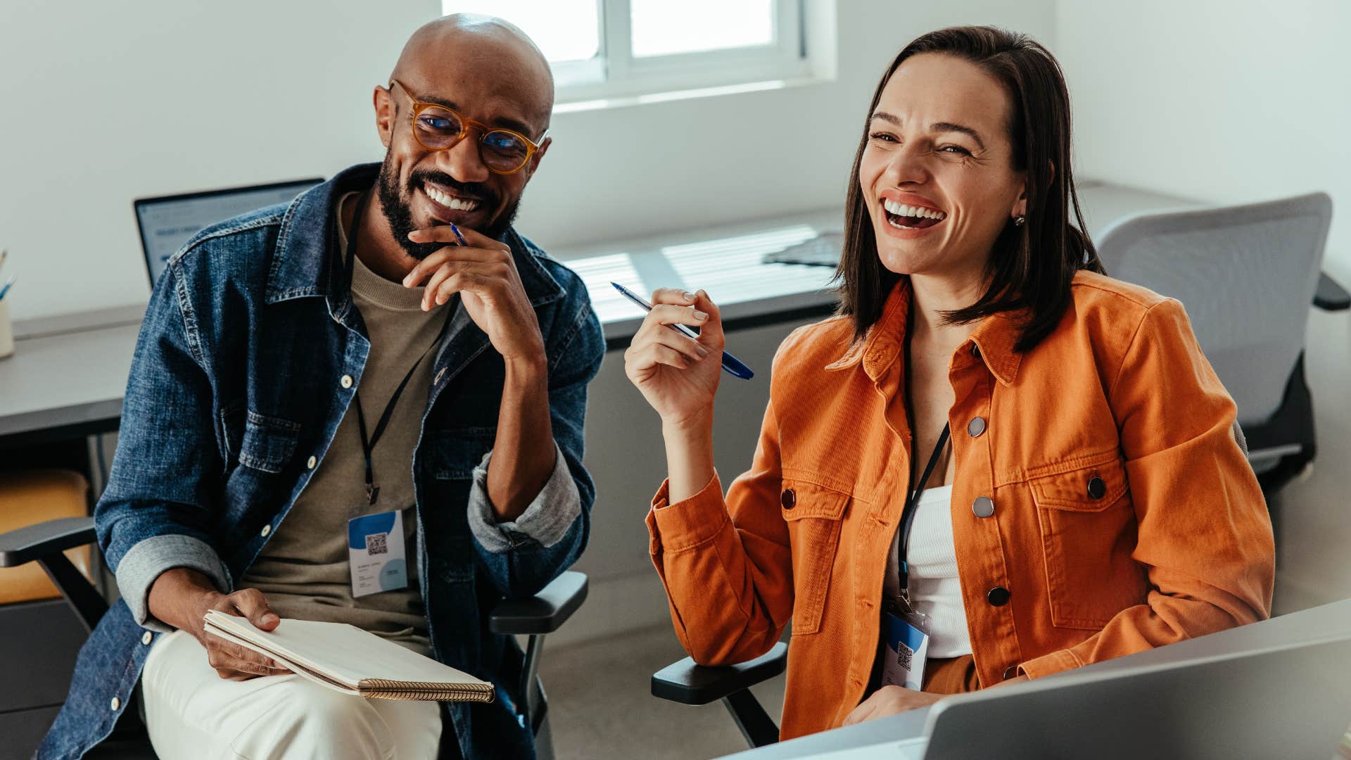 Woman who dresses appropriately at work smiling with a co-worker.