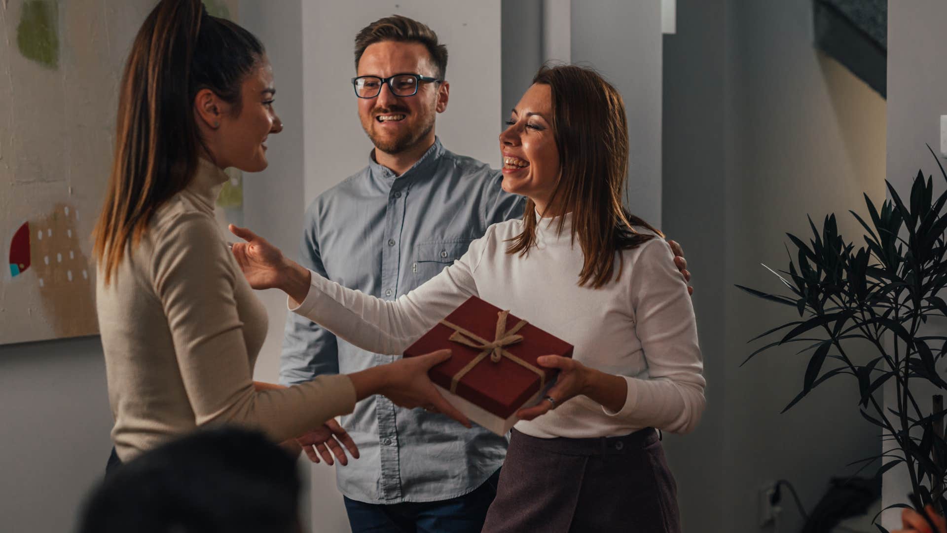 Woman who brings things when invited over talking to the host.