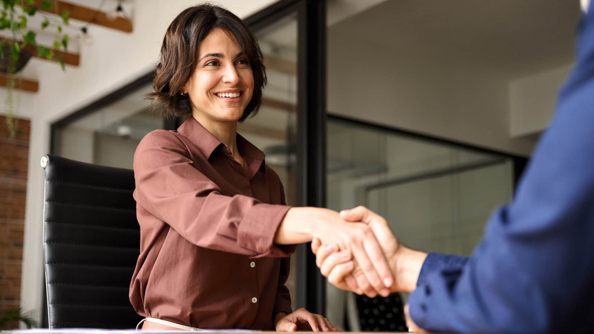 Woman who can remember people's names shaking a man's hand.