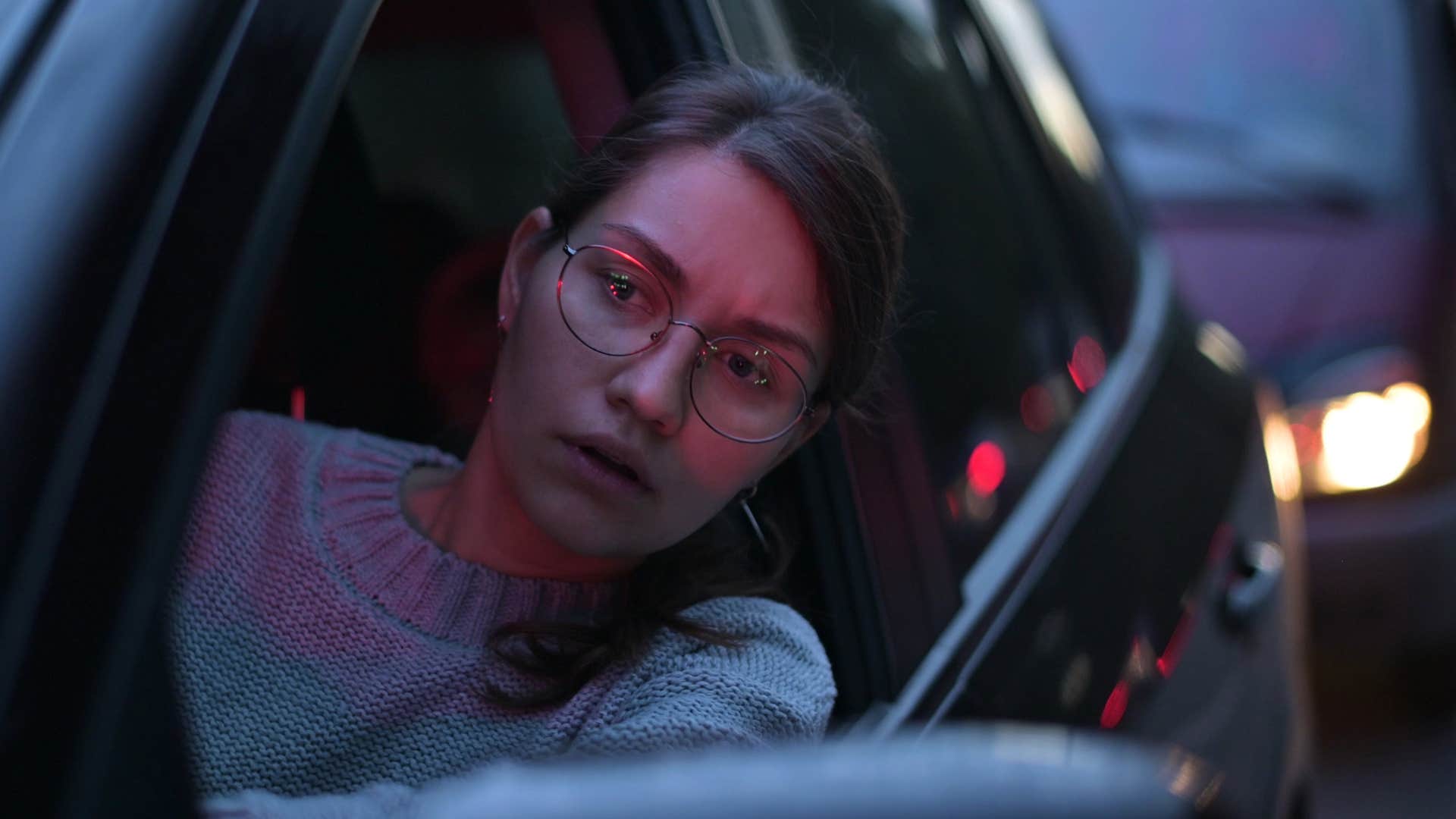 woman stuck in traffic listening to the radio for updates