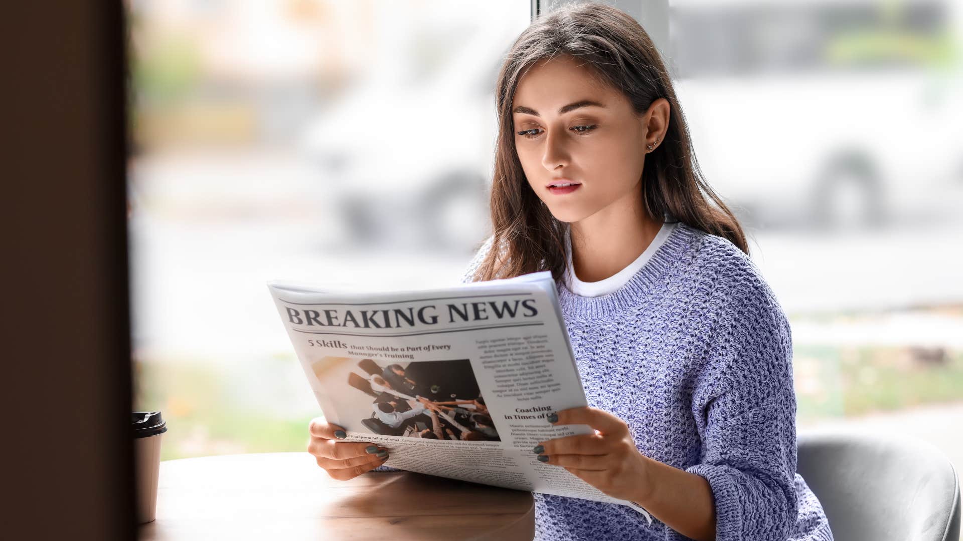 young woman reading the newspaper for information