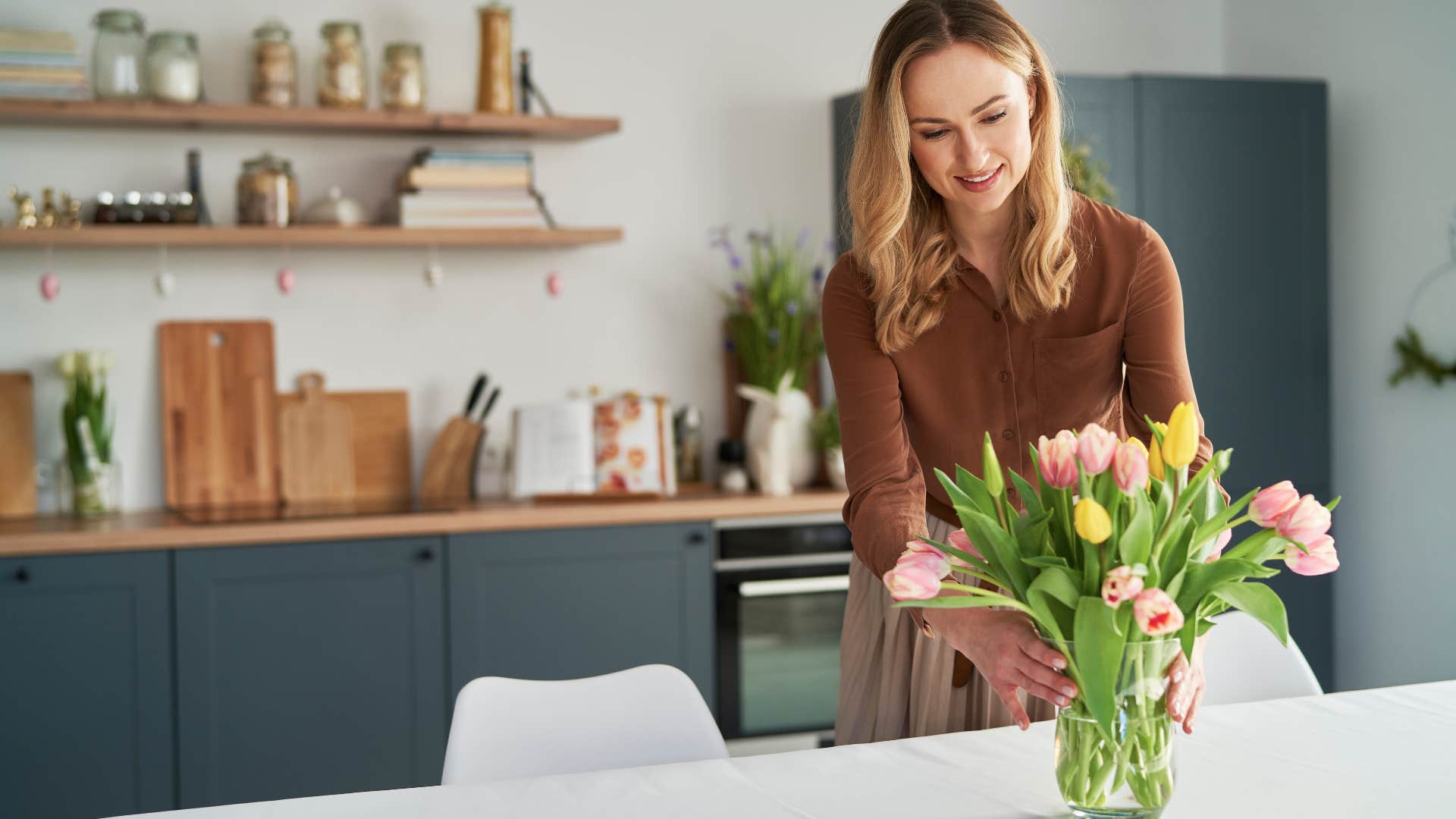 woman putting fresh flowers in vase