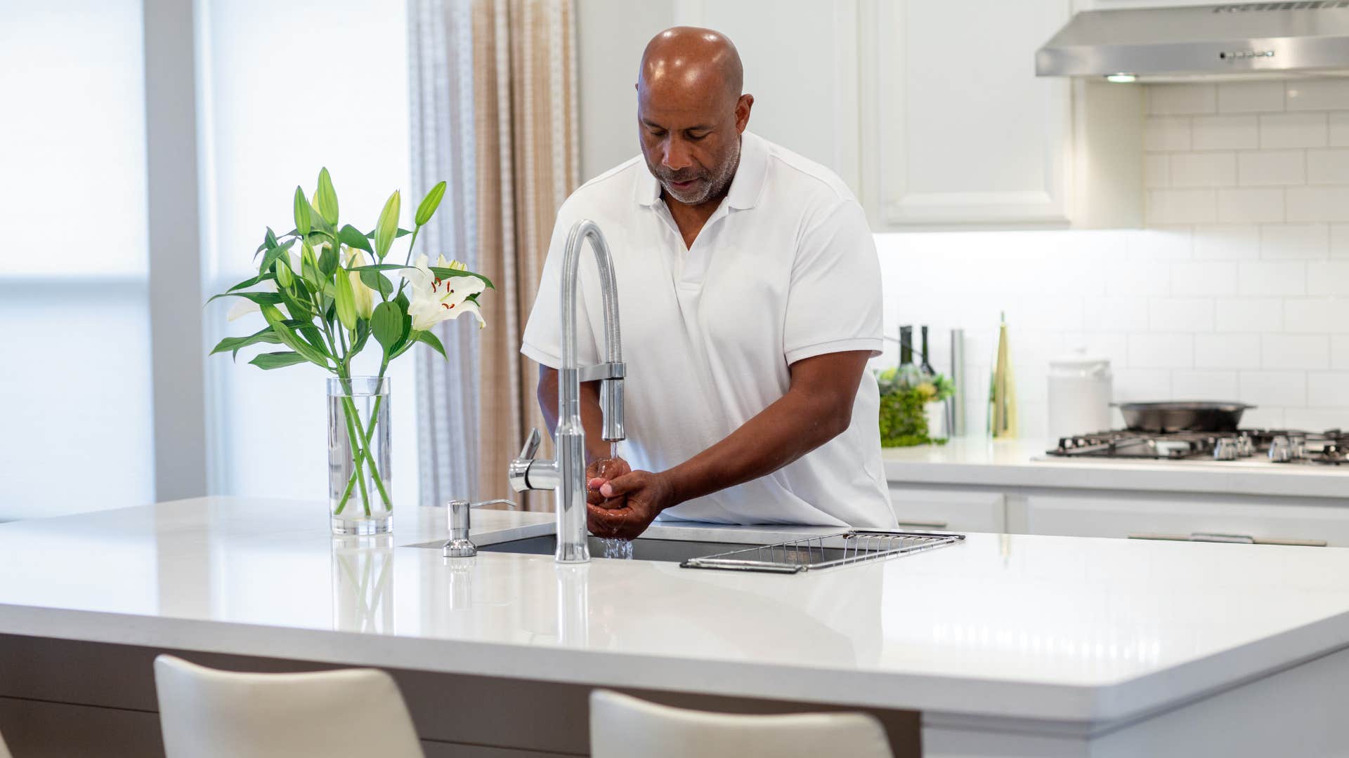 man washing his hands in kitchen