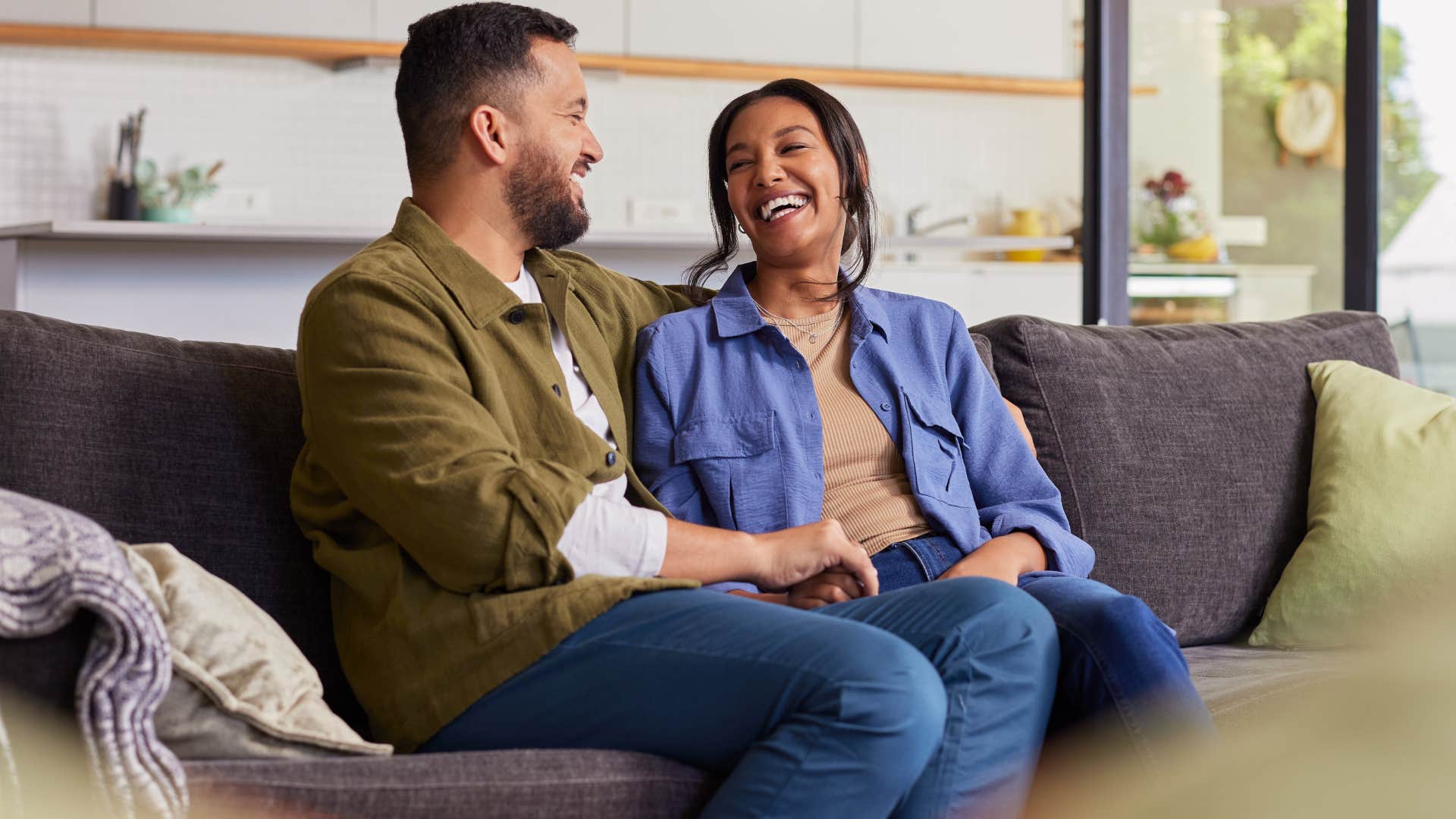 Couple smiling and sitting in their home with no clutter.