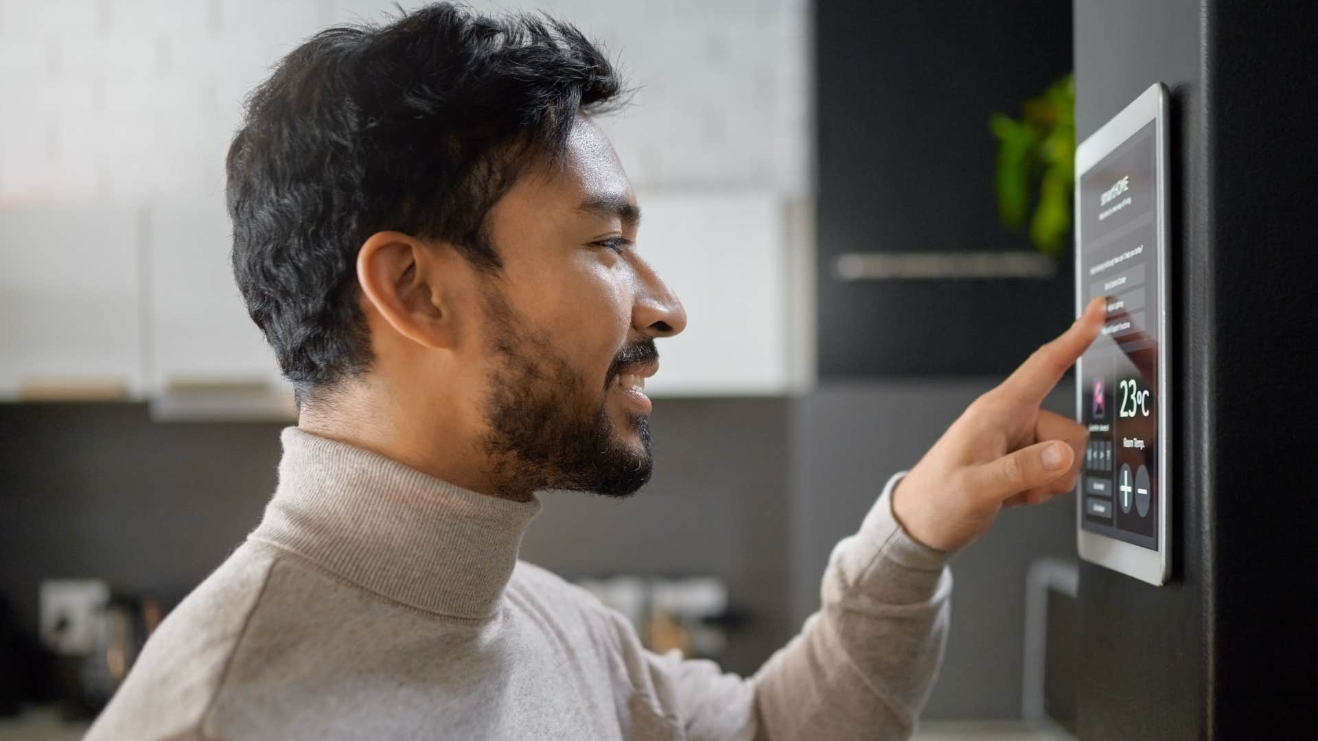 Man using smart home features in his kitchen.