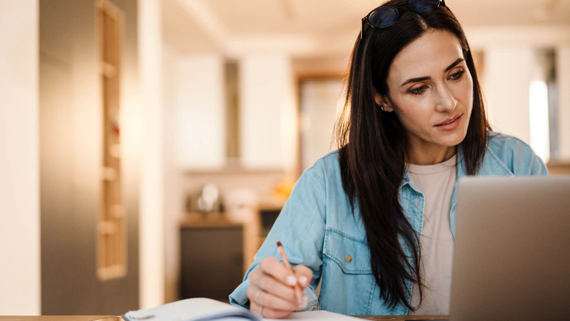 Woman using physical calendars and planners at home.