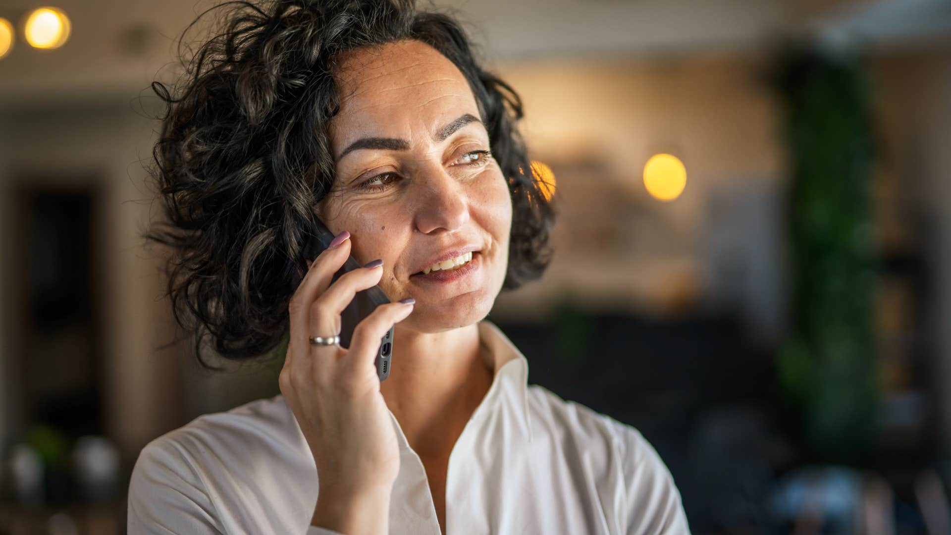 Woman talking on the phone and smiling.