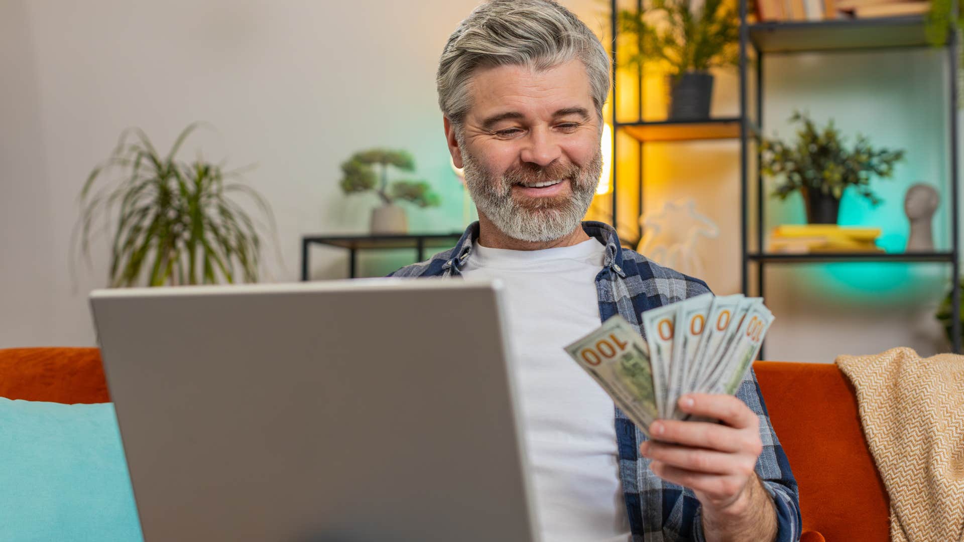 Man using cash at home on his computer.