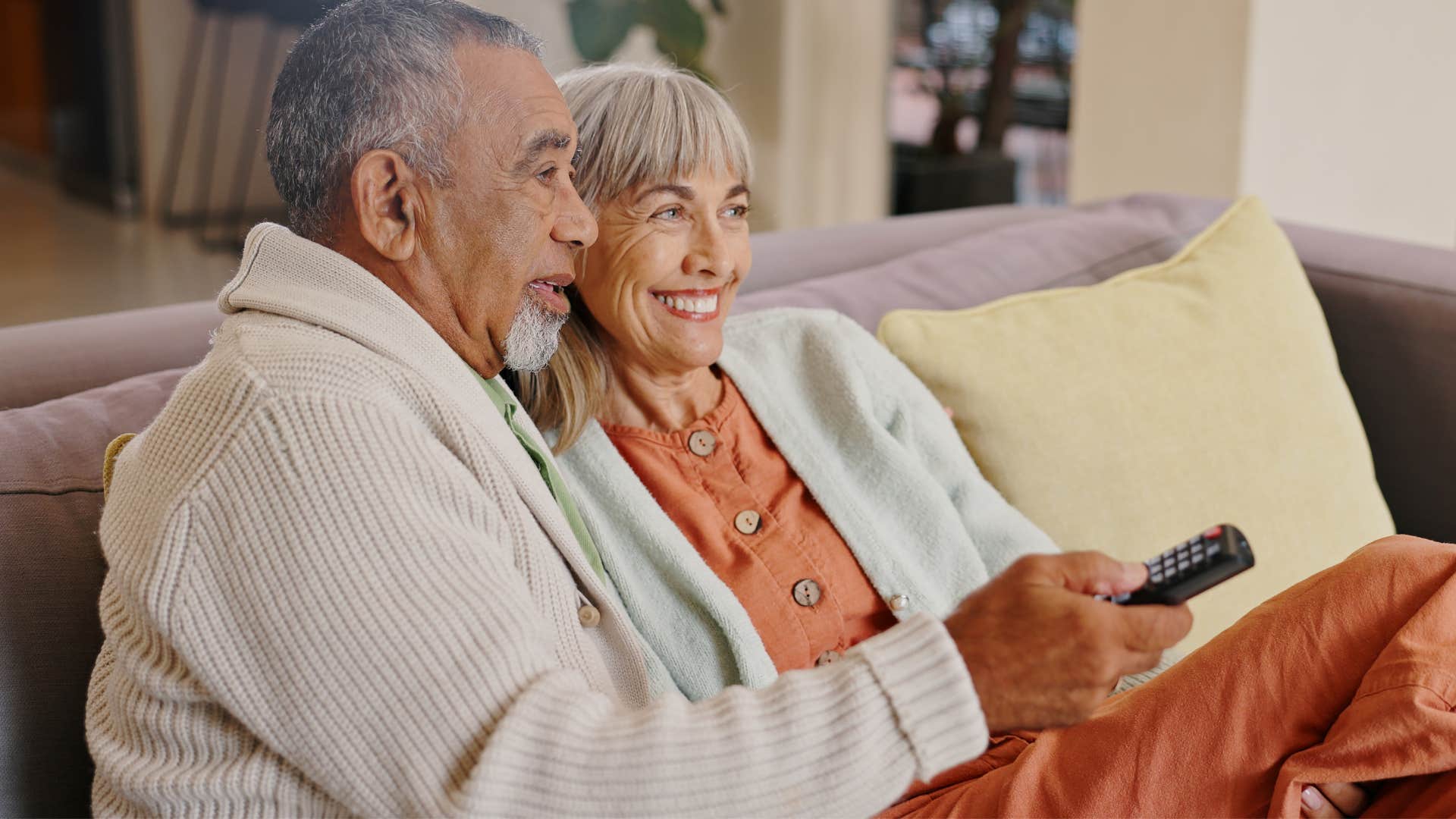 Couple watching the news on TV at home.