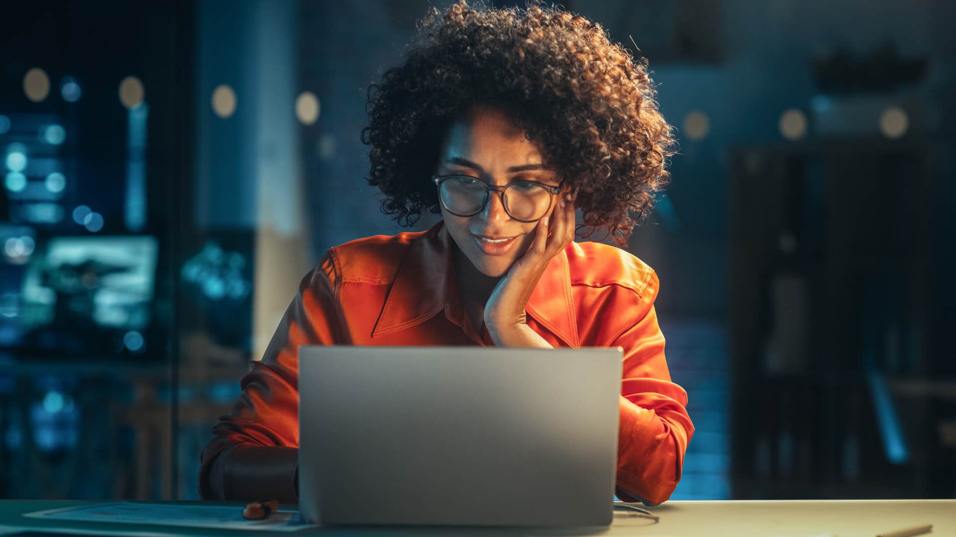 Woman problem-solving in her office at night.