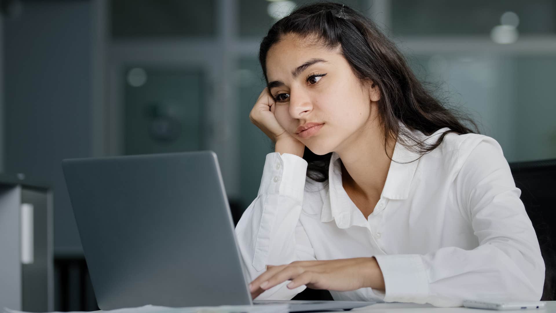 Woman who puts in minimal effort working at the office.