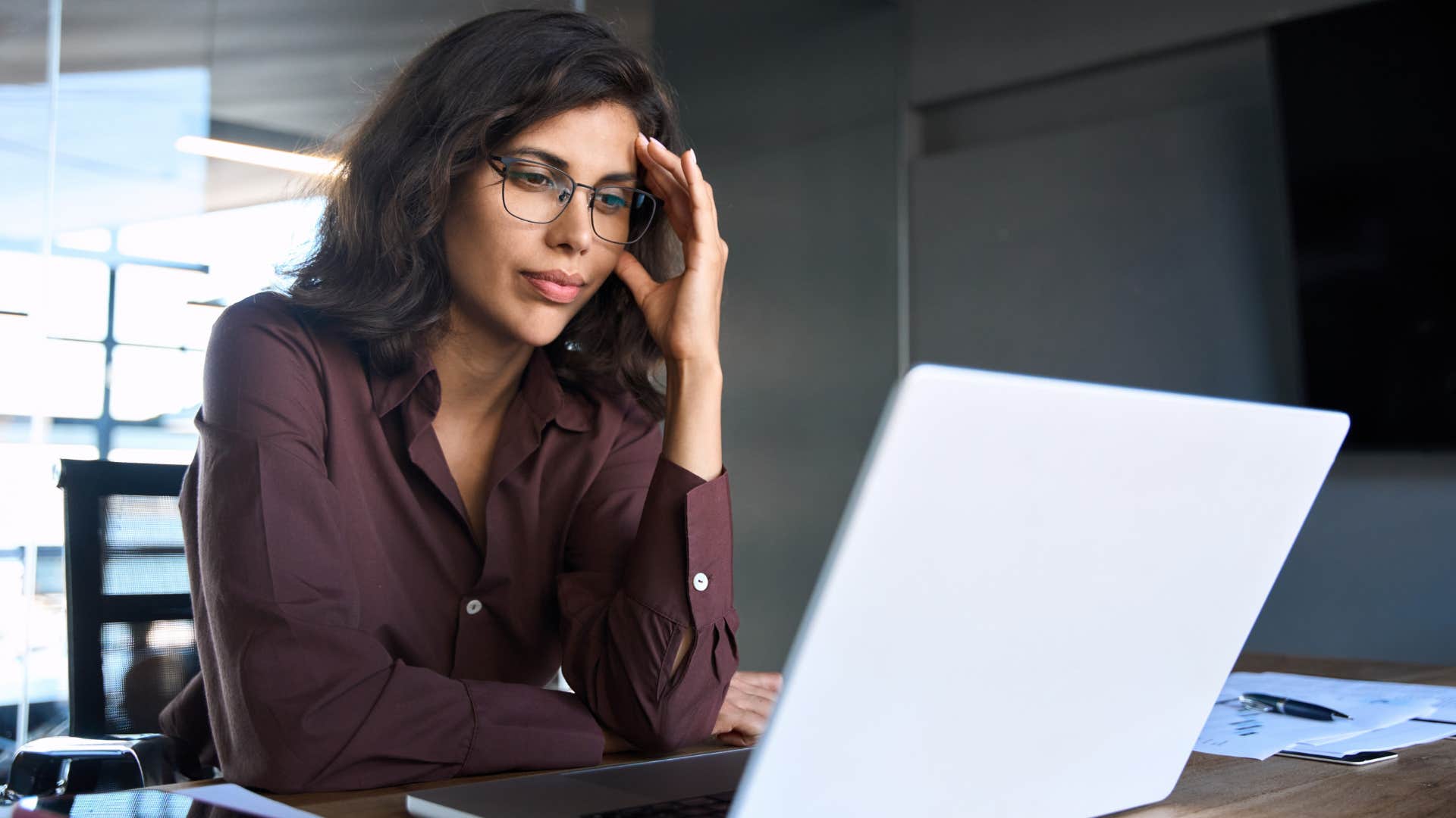 Woman who's on job boards at work looking at her laptop.