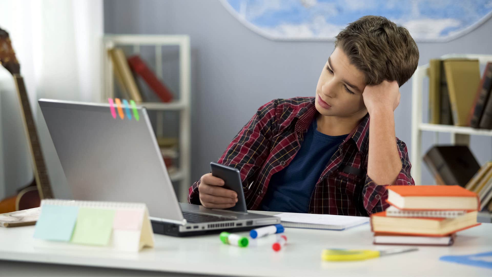 teenage boy refusing to do chores as he scrolls through phone