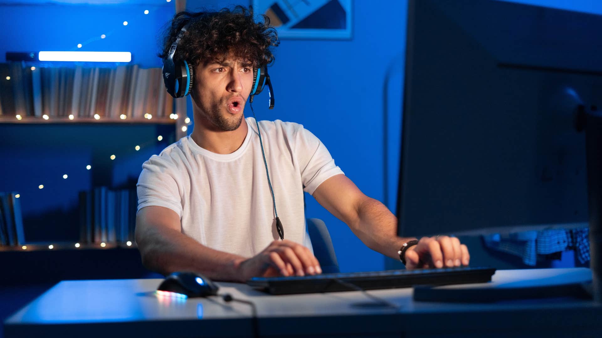 man in white shirt playing video games as he finds things to distract him