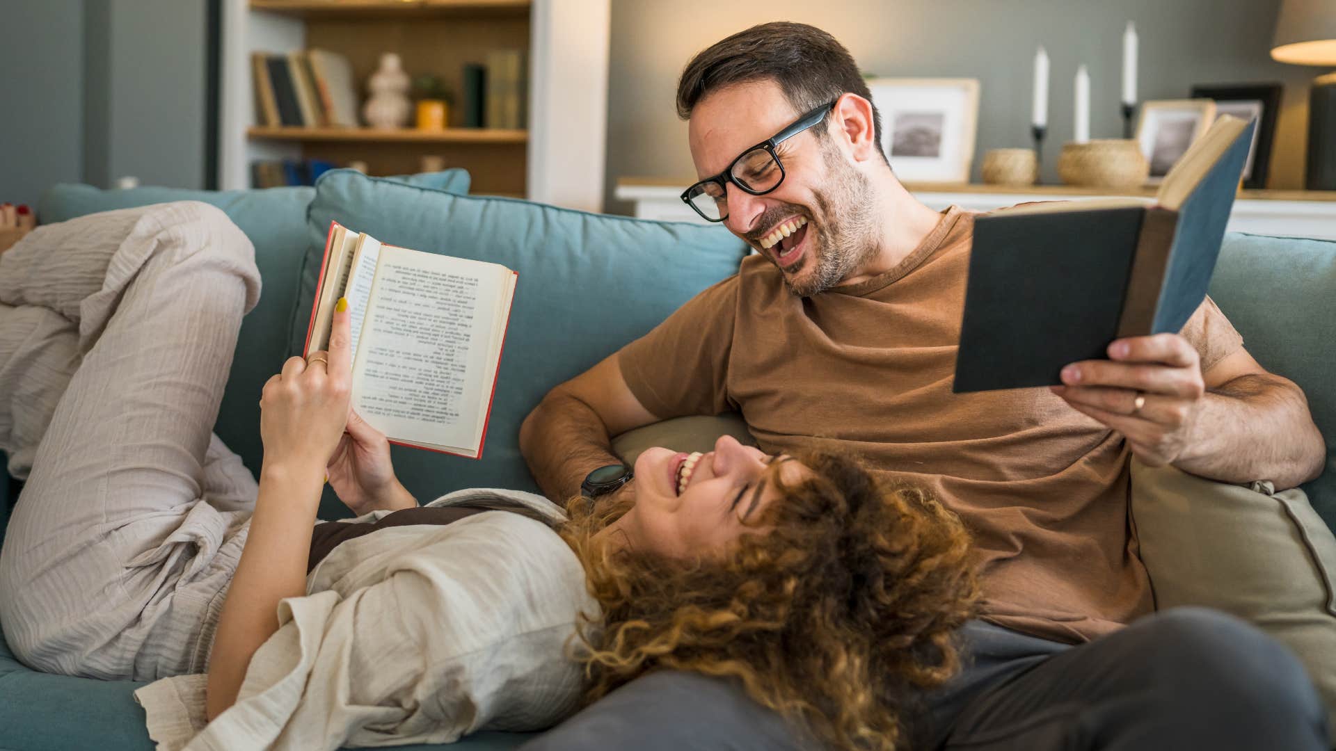 Woman smiling and reading books with her husband at home.