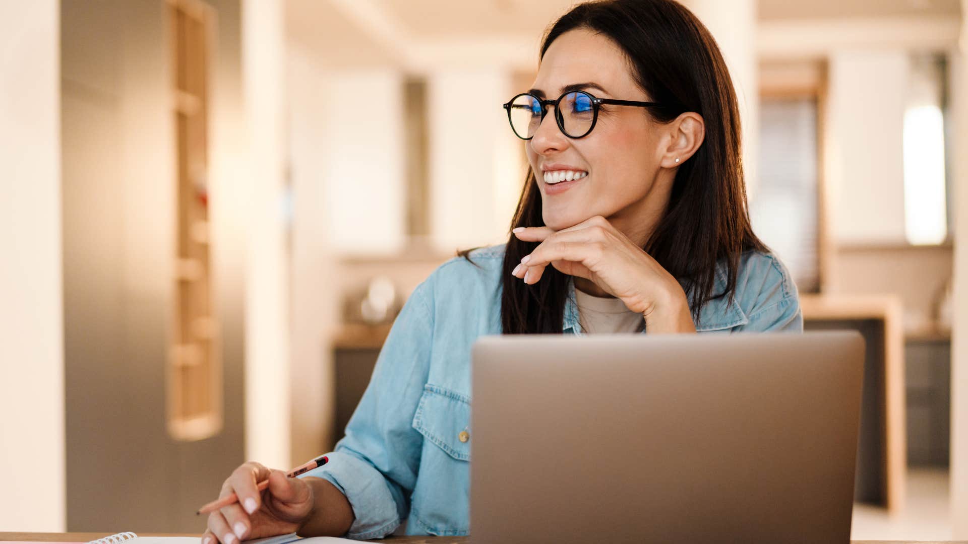 Woman smiling and writing in a physical calendar.