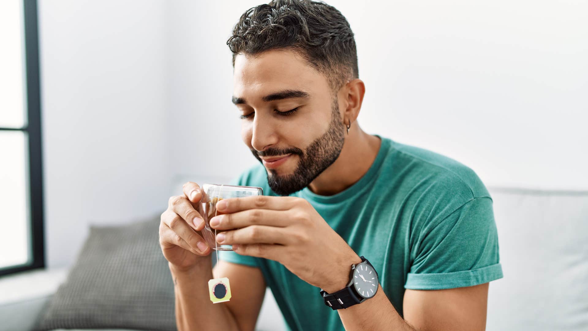 Man drinking tea or coffee at home.