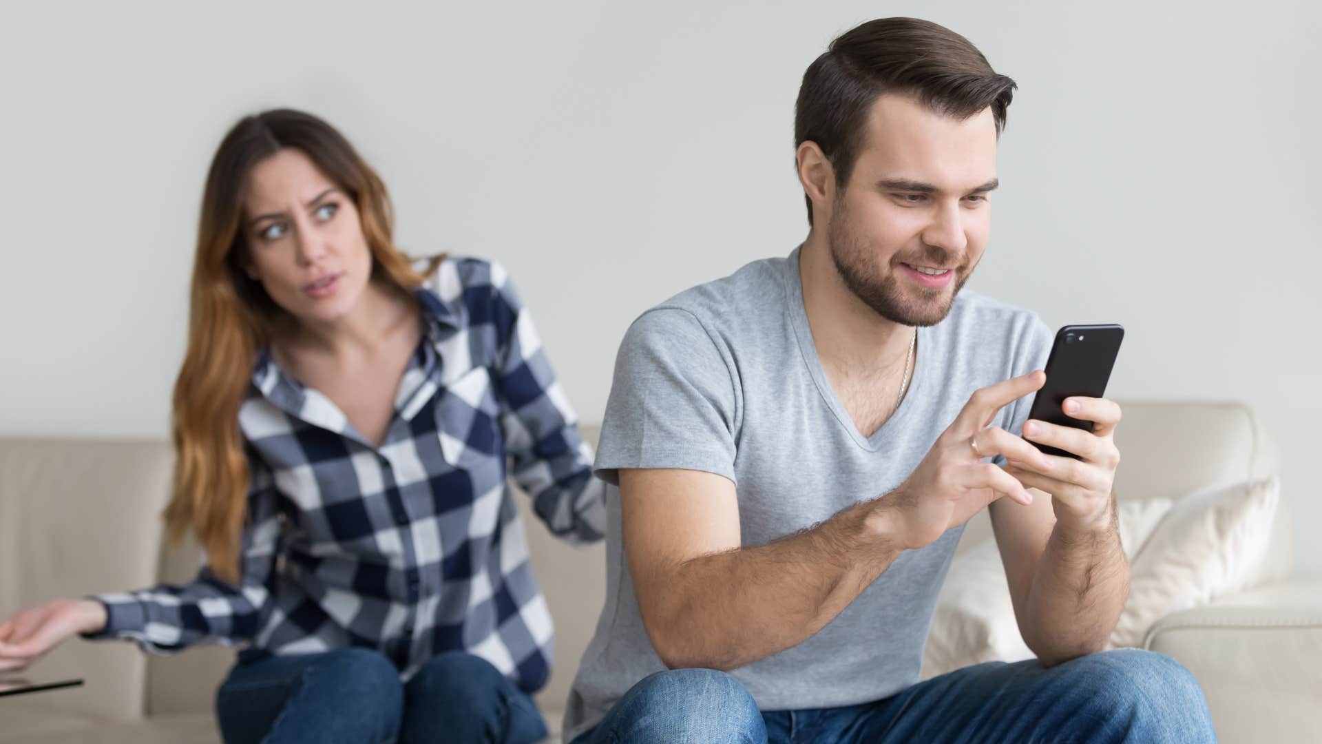 a husband ignores talking to his wife to look at his phone instead