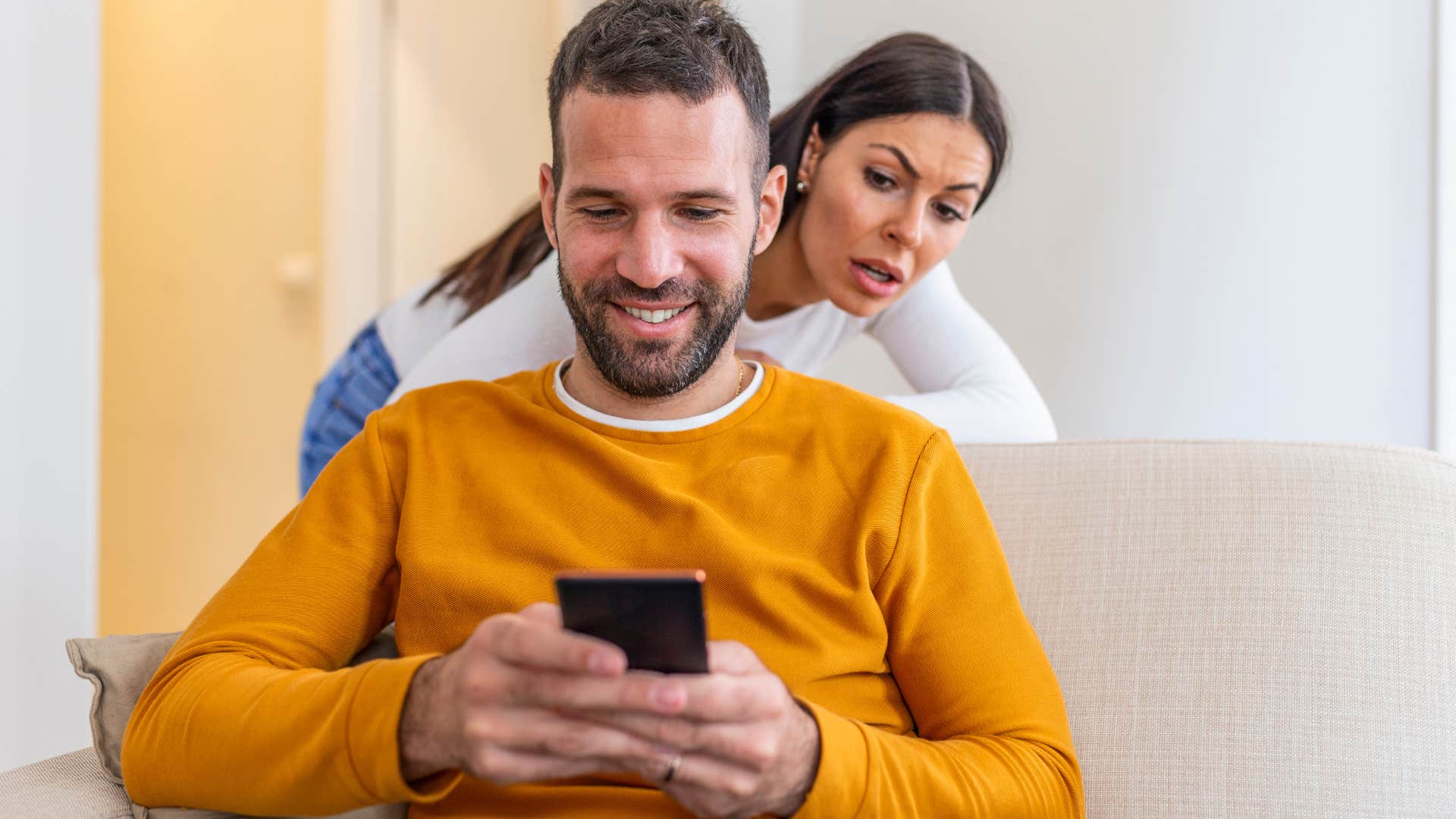 Woman looking at her husband who's always on his phone.