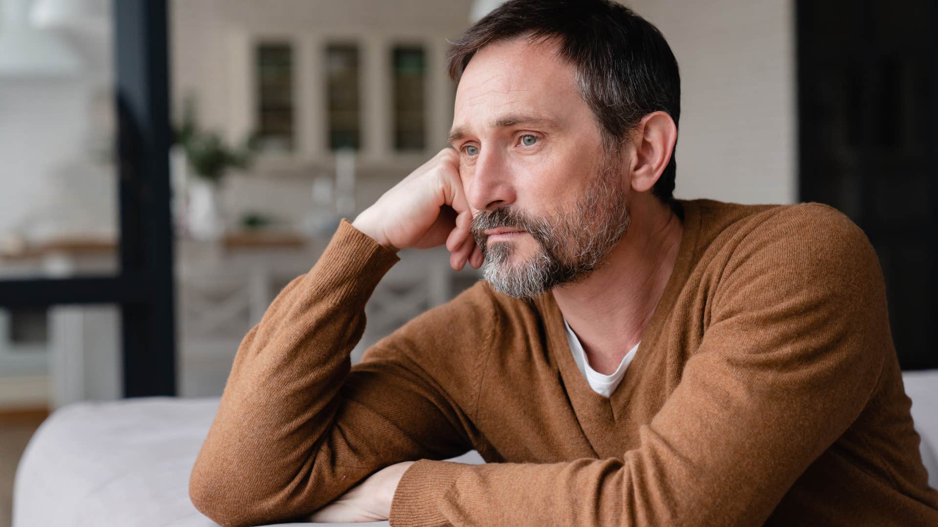 Man who doesn't talk about the future looking out of a window.