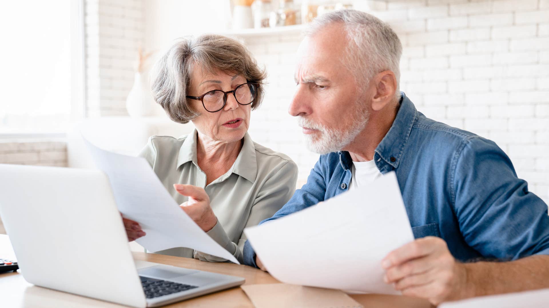 Couple who only has superficial conversations looking at bills.