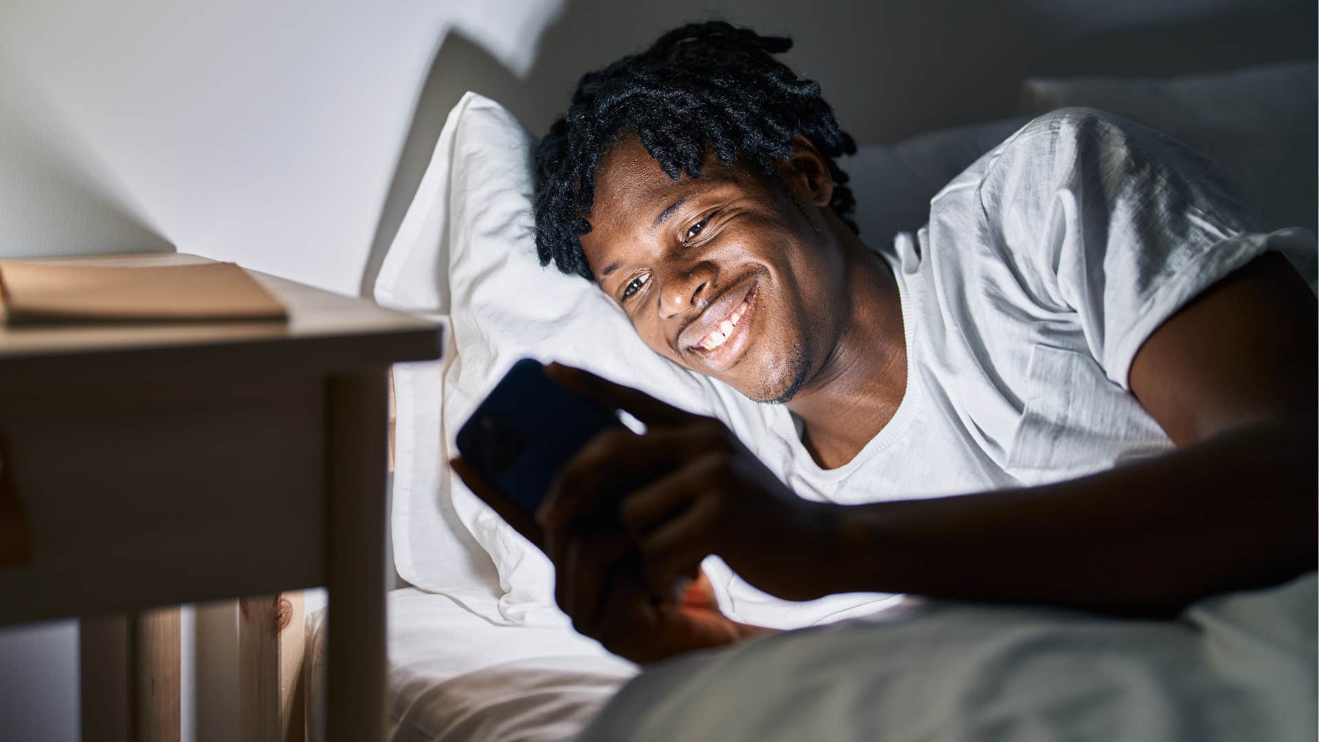 man with different nighttime routines than his wife scrolling on his phone