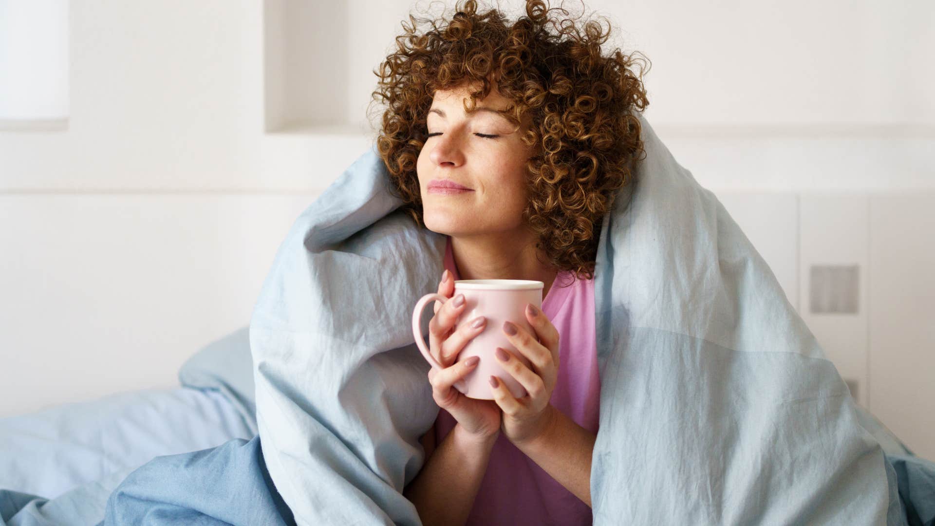 woman whose solitude is sacred drinking coffee alone in bed