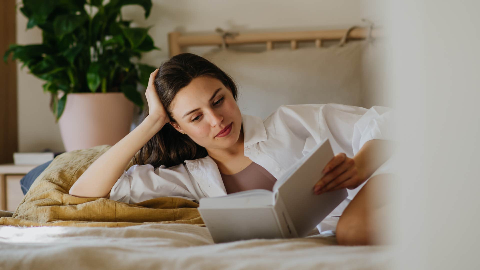 woman with more space for hobbies reading in bed