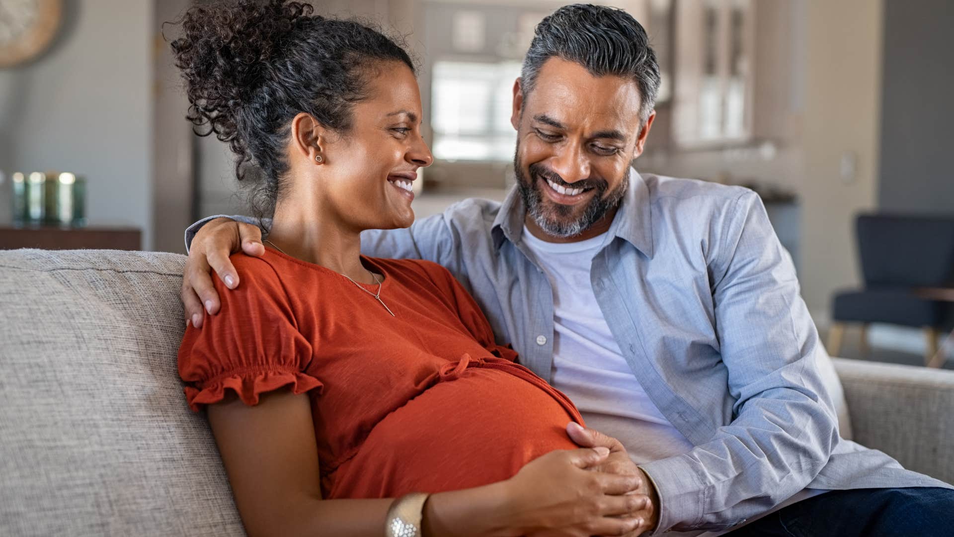 a wife and her husband share a deep bond of intimacy as he rubs her pregnant belly