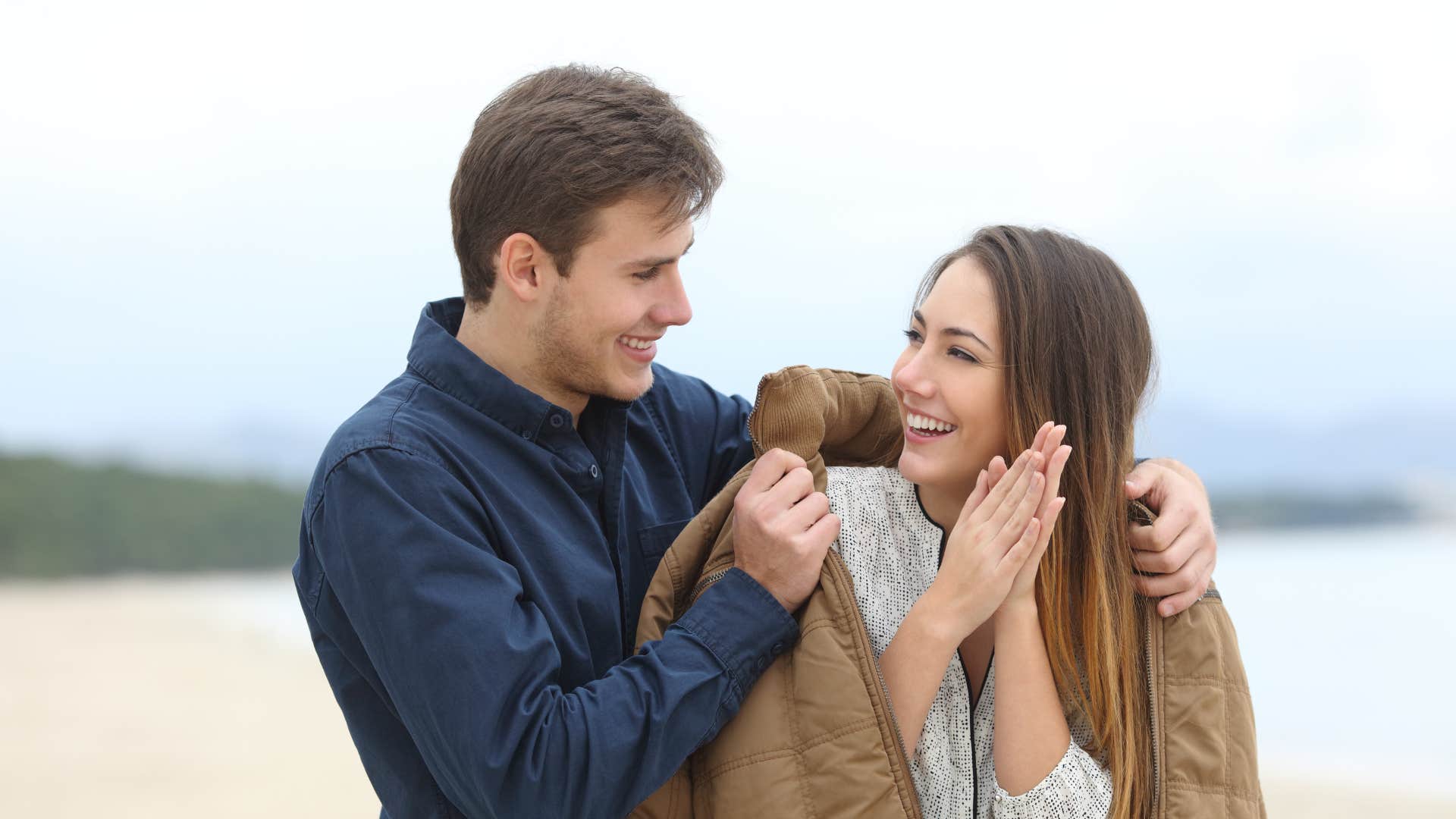 husband putting jacket on wife's shoulders