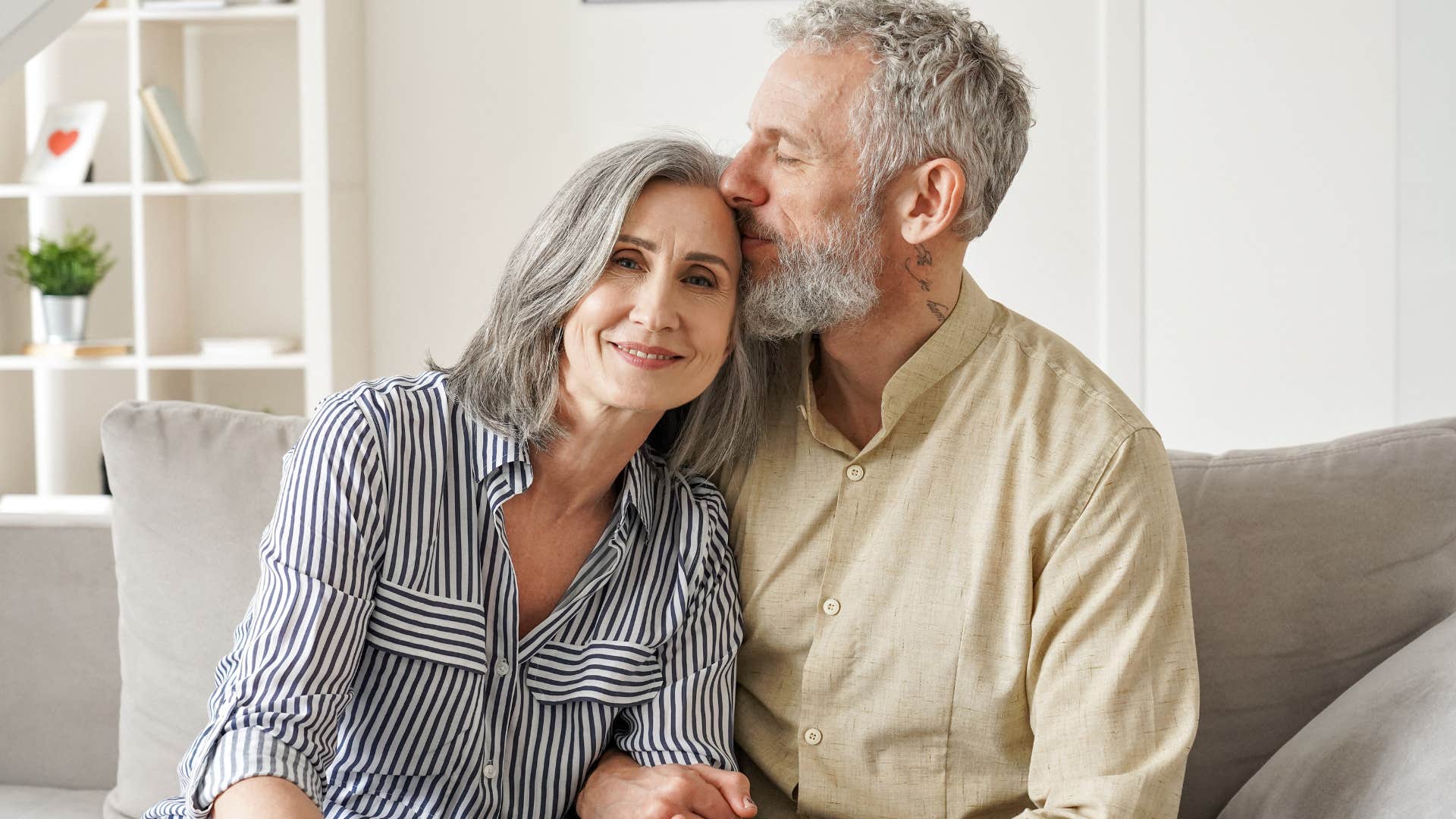 husband comforting wife by kissing her head