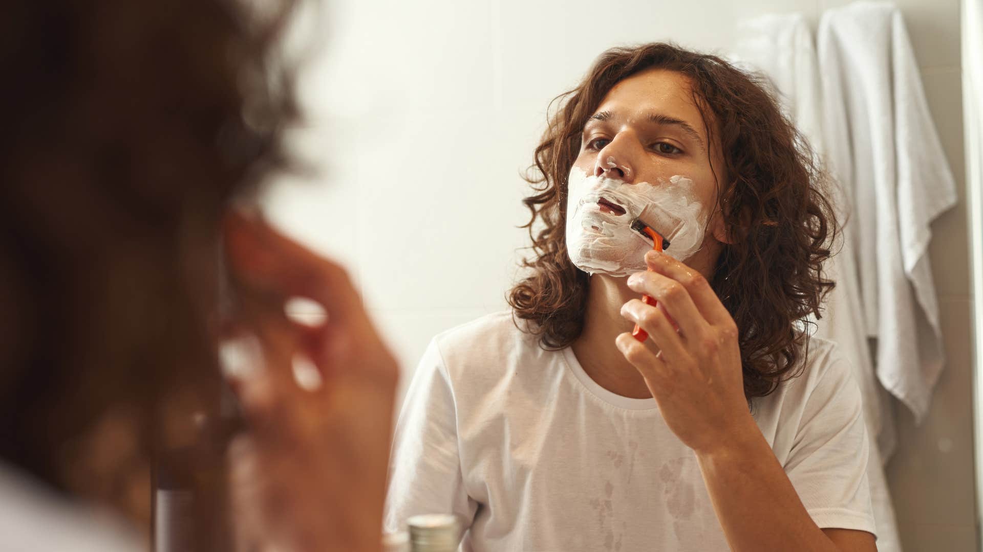 man shaving in mirror
