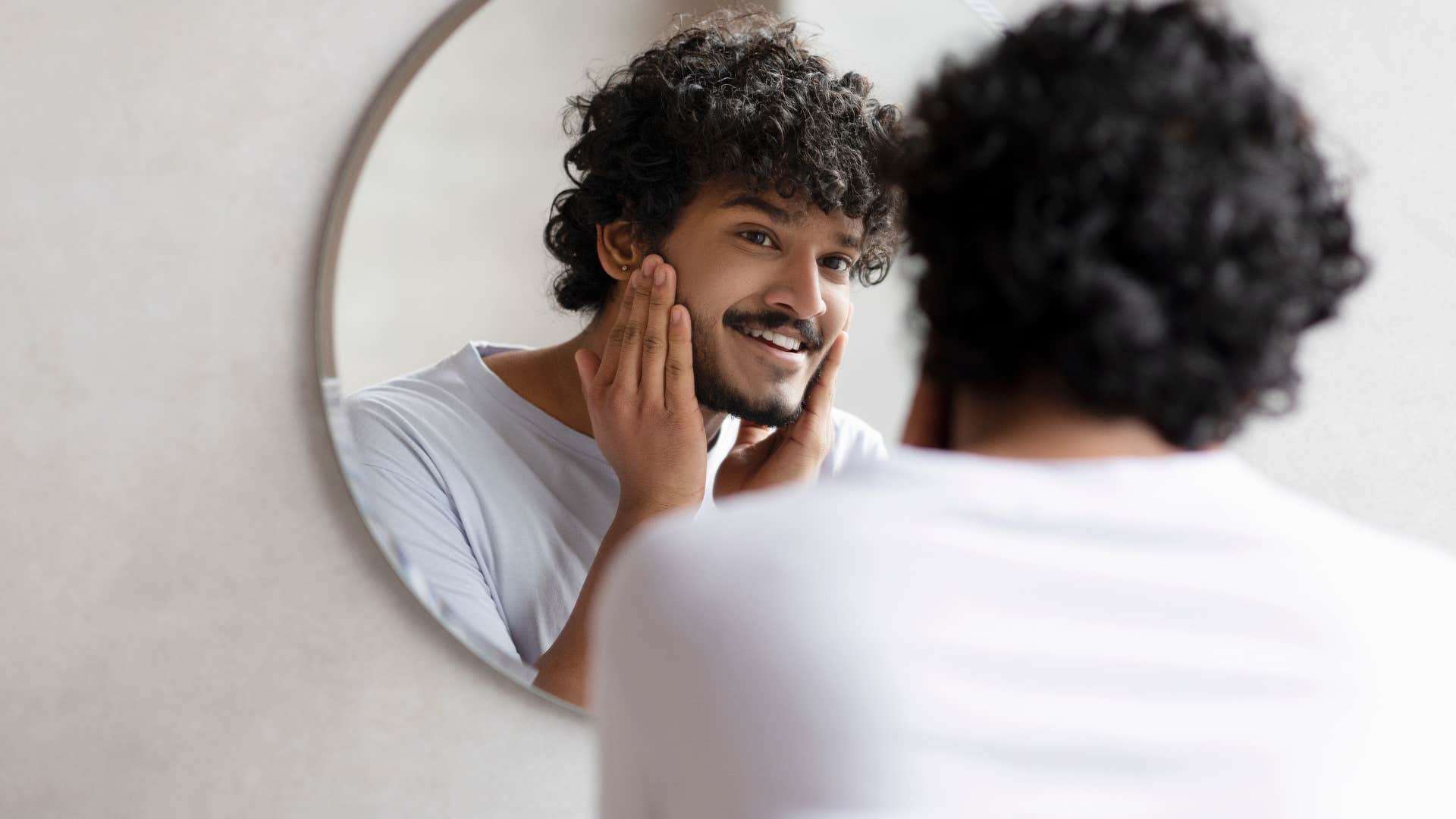 man looking at reflection of himself in mirror