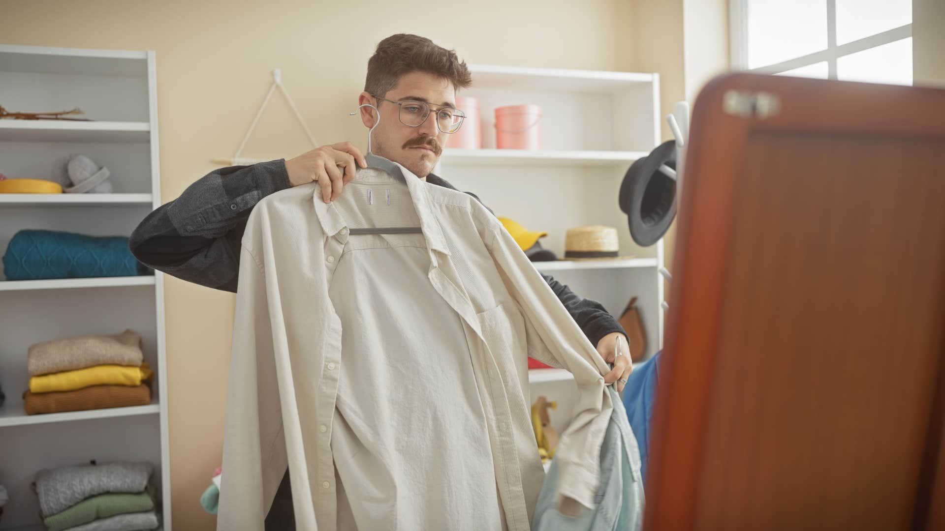 man trying on old clothes