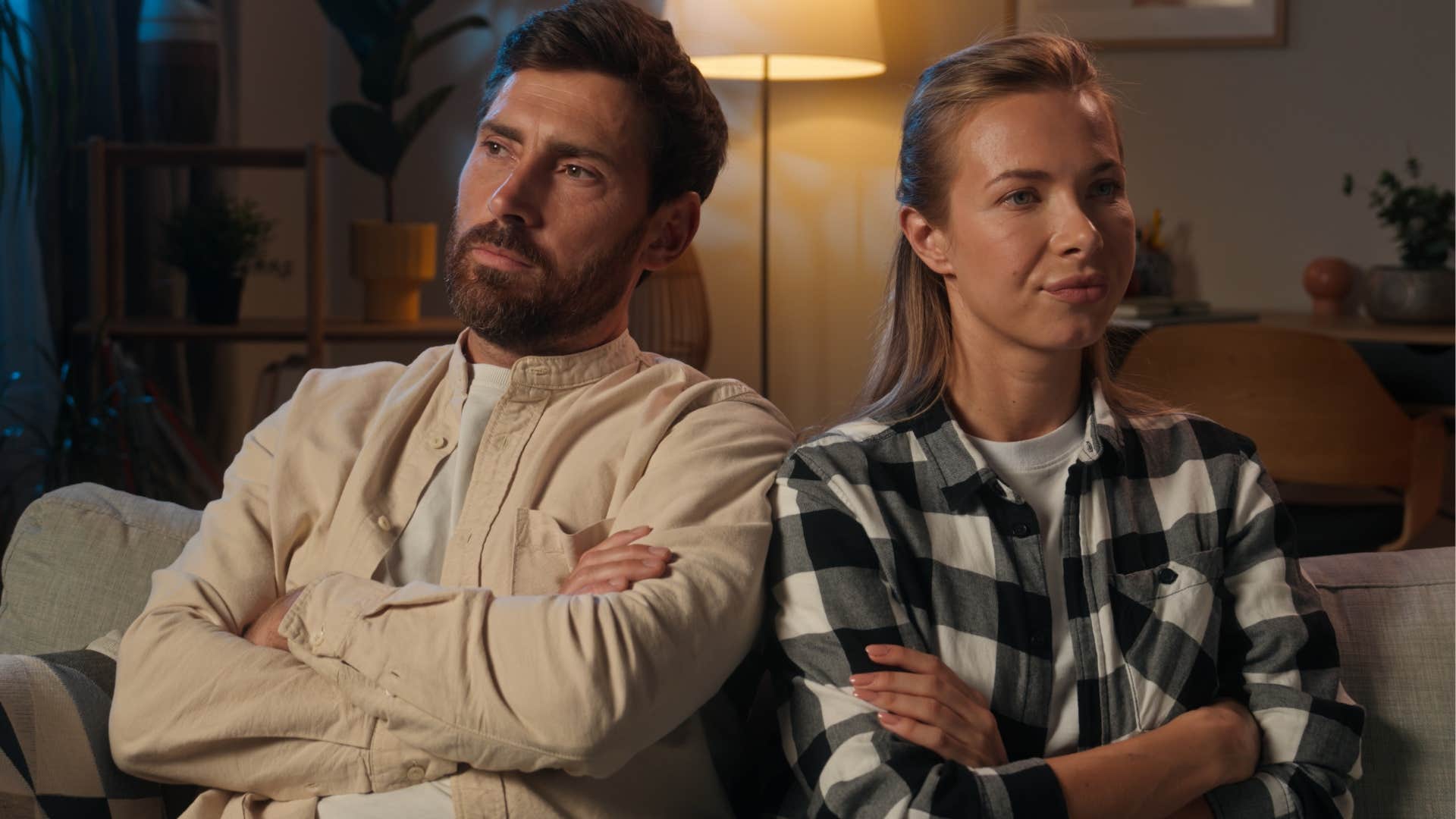 Man who's not emotionally warm sitting next to his wife.