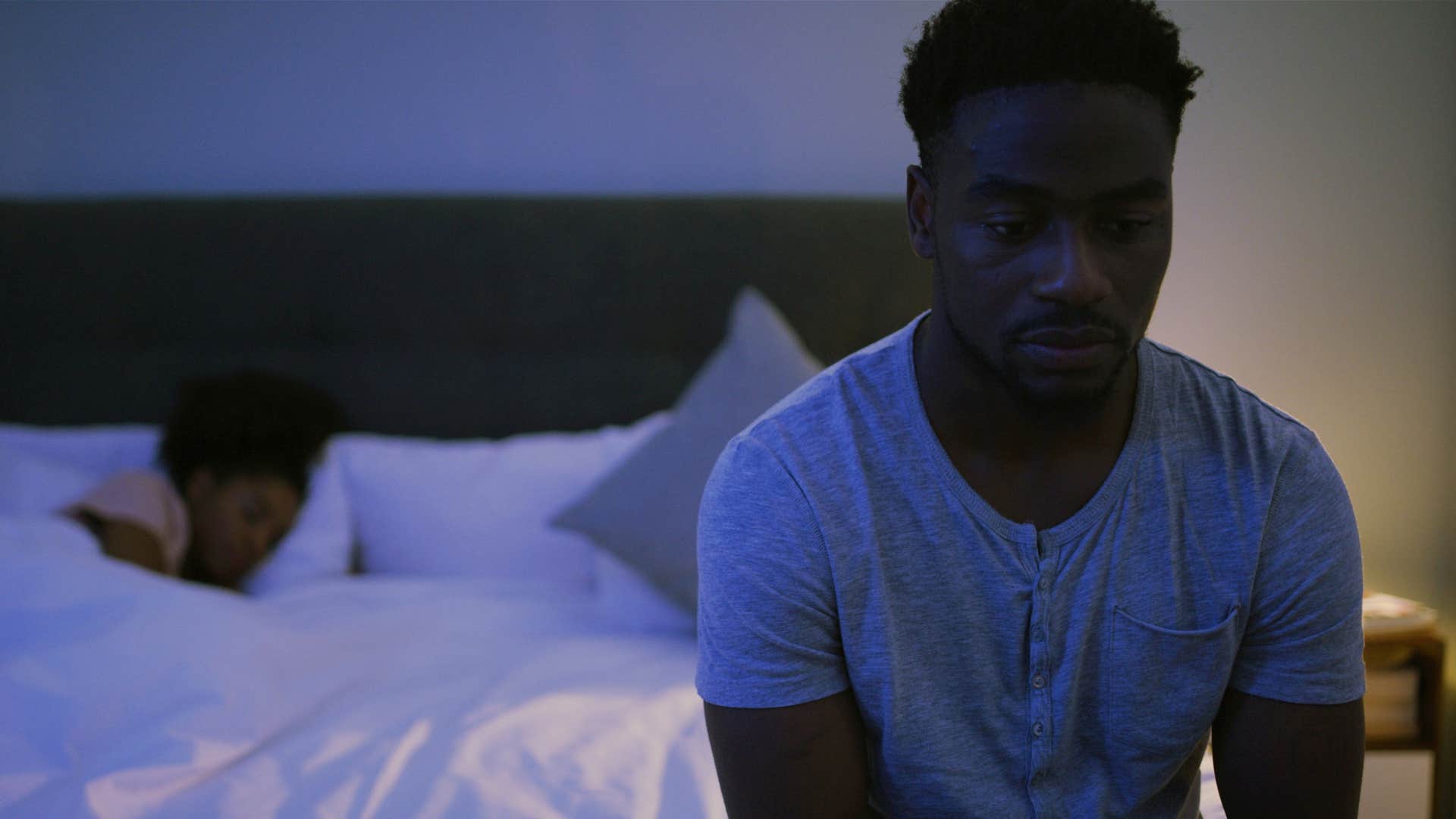 Man who doesn't say "goodnight" sitting on his bed alone.