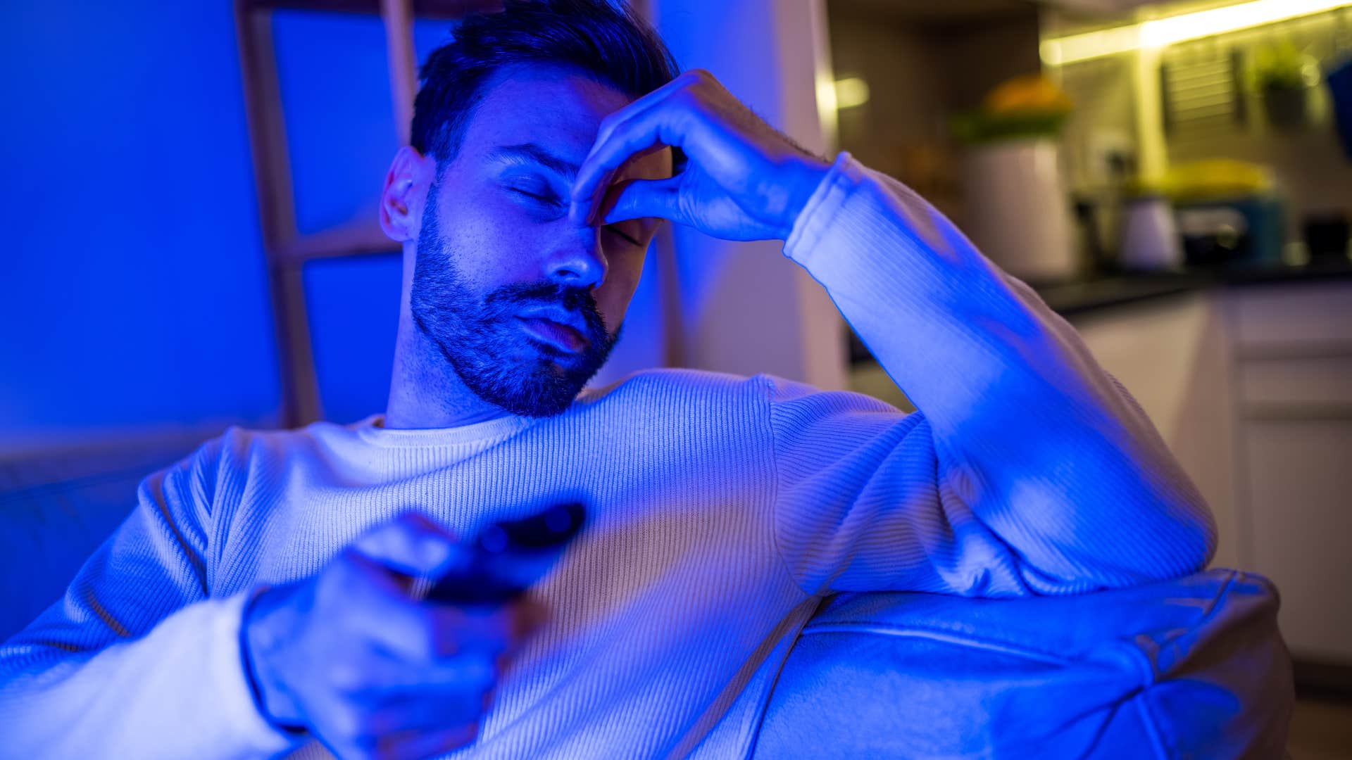 Man who watches TV constantly sitting on his couch.