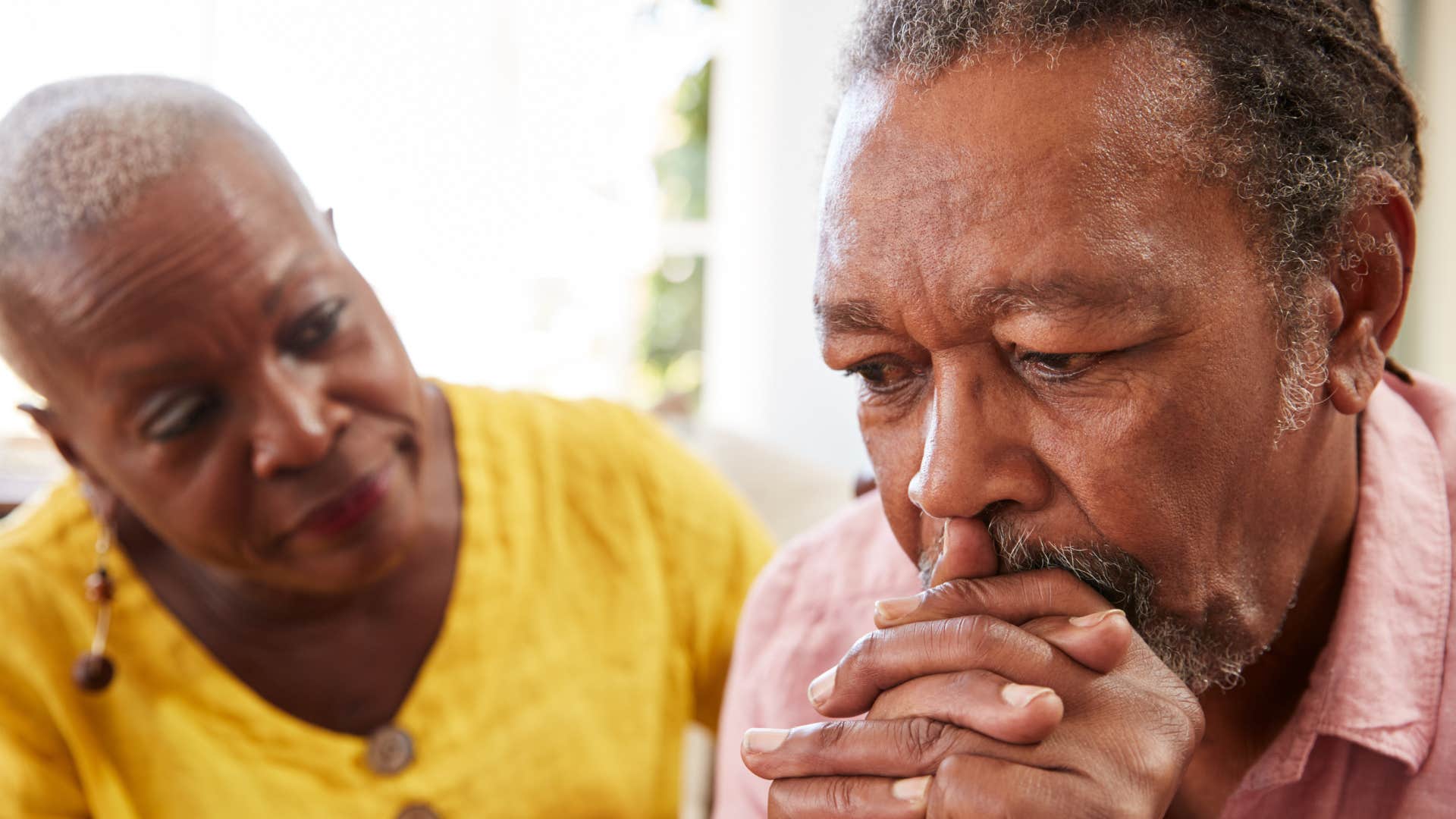 man thinking I'm afraid of losing you while sitting next to his wife