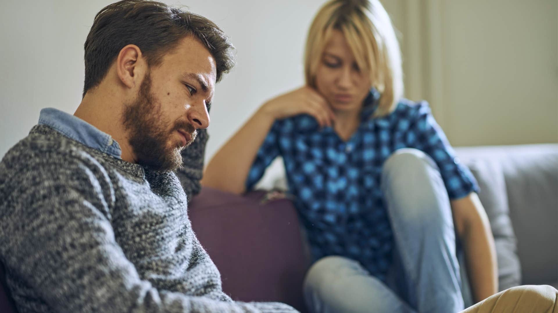 Couple who never talks through conflicts sitting on a couch.